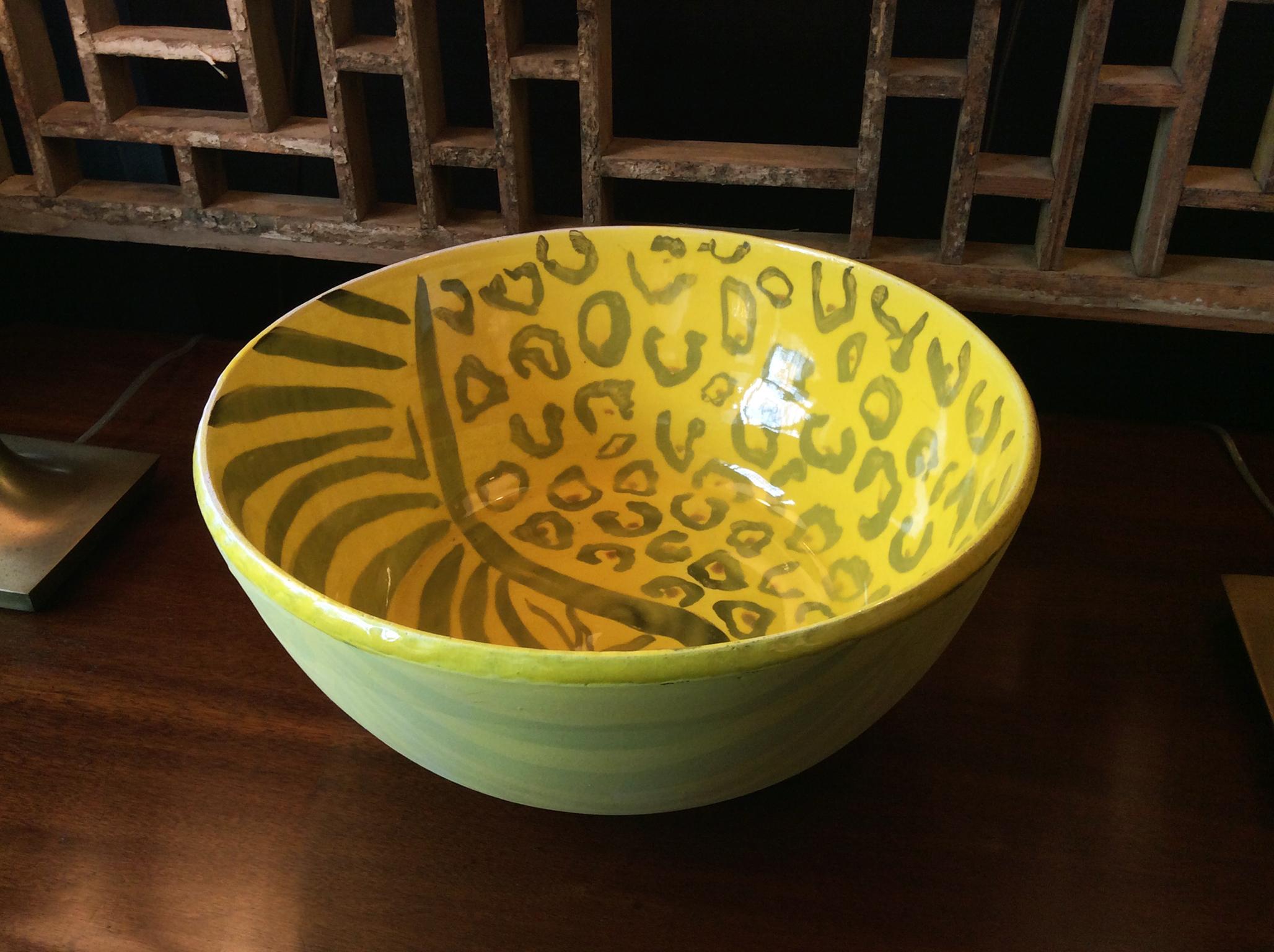 A ceramic stoneware bowl by Thom Lussier, from his series of beautifully patterned vessels, some with zebra stripes, others with more subtle but nevertheless rich, painterly surfaces. This bright yellow bowl is a mix of various finishes. The