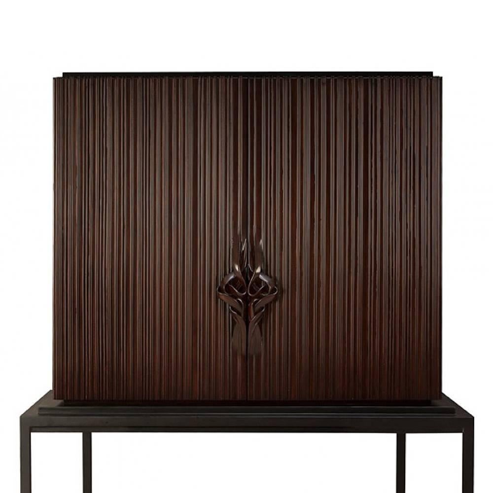 Bar Thomas with structure in solid mahogany wood,
totally hand-crafted, hand-carved wood. Base in black
satin solid wood. Inside in coral lacquered solid wood
mahogany. With inside back in mirror glass, two drawers
in handcrafted coral lacquered
