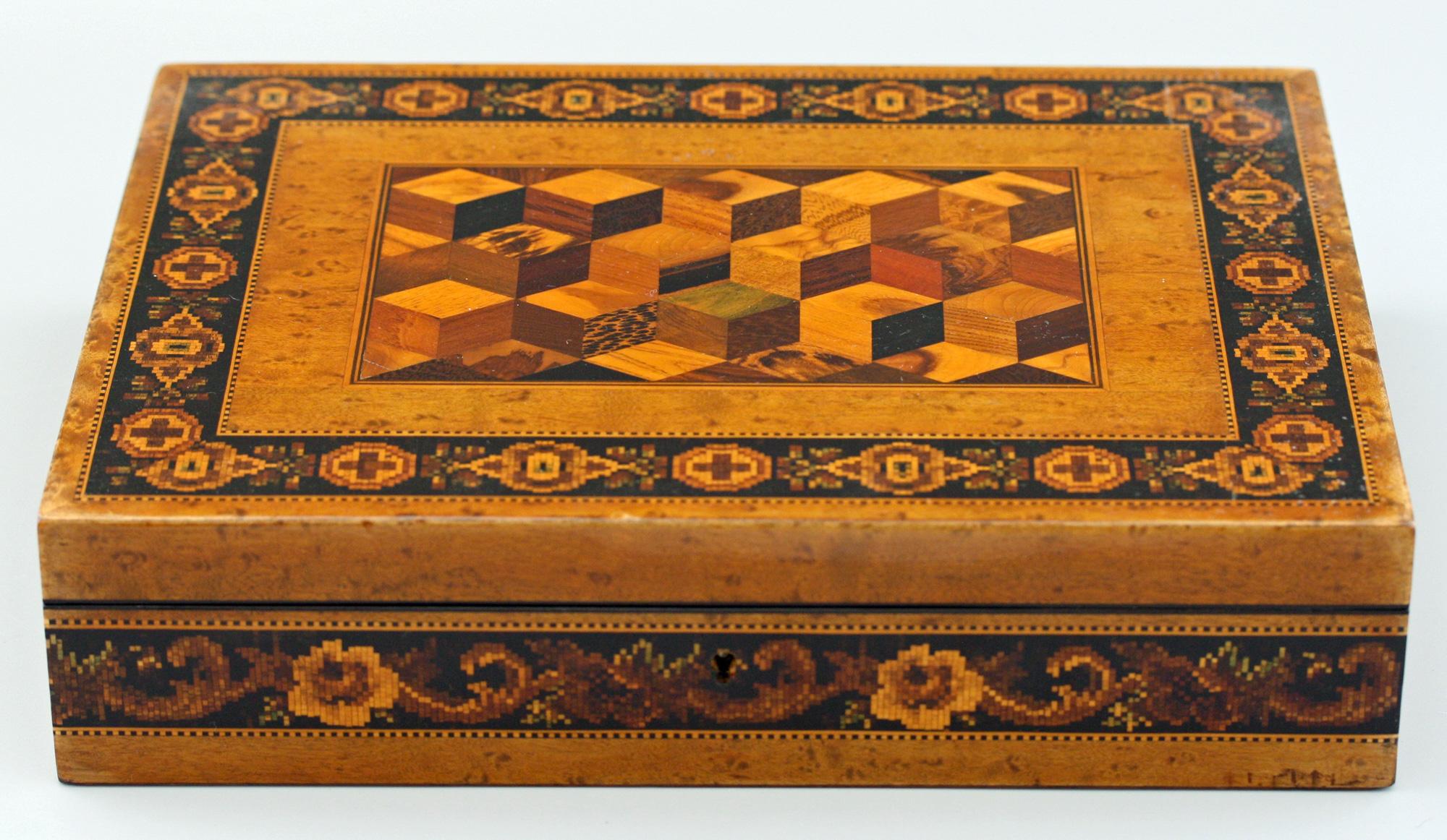 An exceptional and original antique wooden Tunbridge ware box, possibly for games, made by Thomas Barton (1819-1903). This exquisite, versatile and well sized box has a hinged cover decorated with a cube work panel within a geometric mosaic border