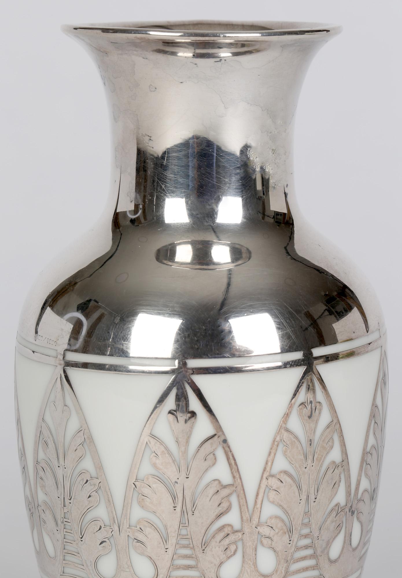 A finely made Art Deco German Bavarian porcelain vase with silver overlay by Thomas and dating from around 1930. The vase of bulbous shape stands on a narrow rounded foot with a funnel shaped neck and trumpet shaped top. The vase made in white