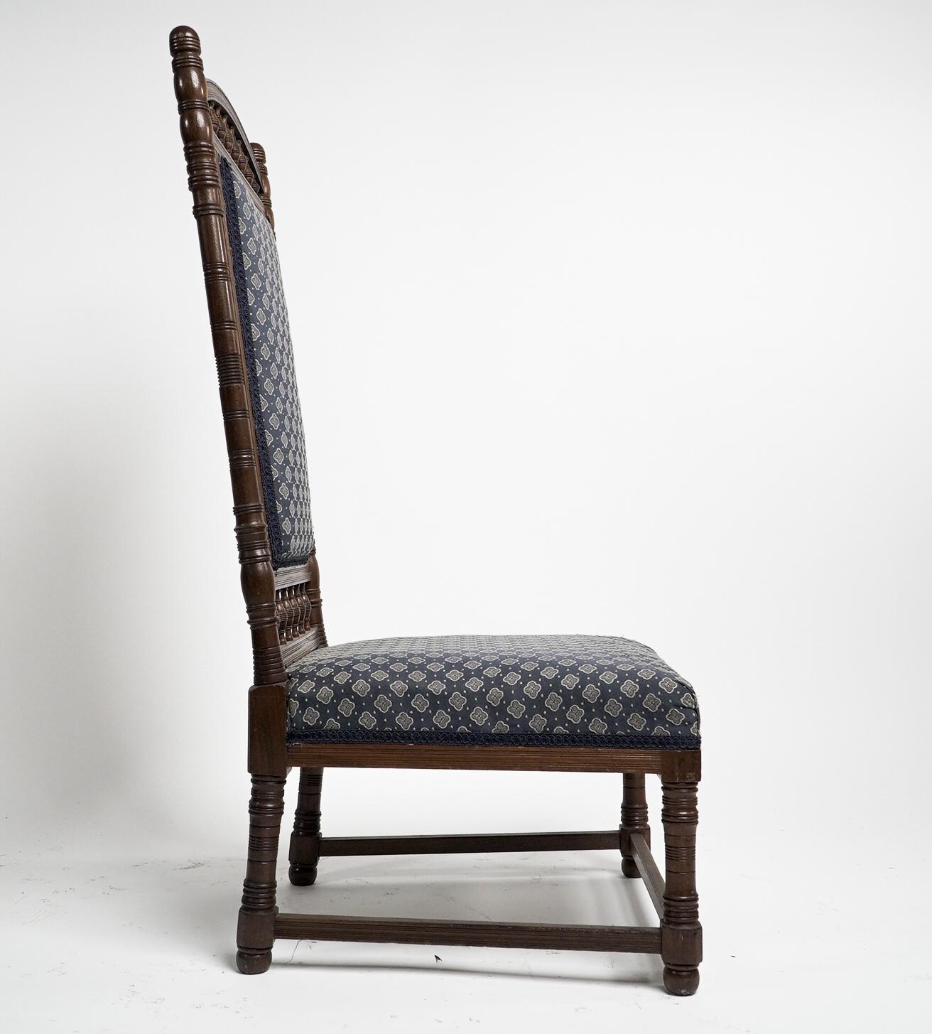 Thomas Edward Collcutt pour Collinson & Lock. Chaise à haut dossier en noyer du mouvement esthétique, de belle qualité, avec une tapisserie bleue plus tardive. 
Illustré dans le catalogue Collinson and Lock.
