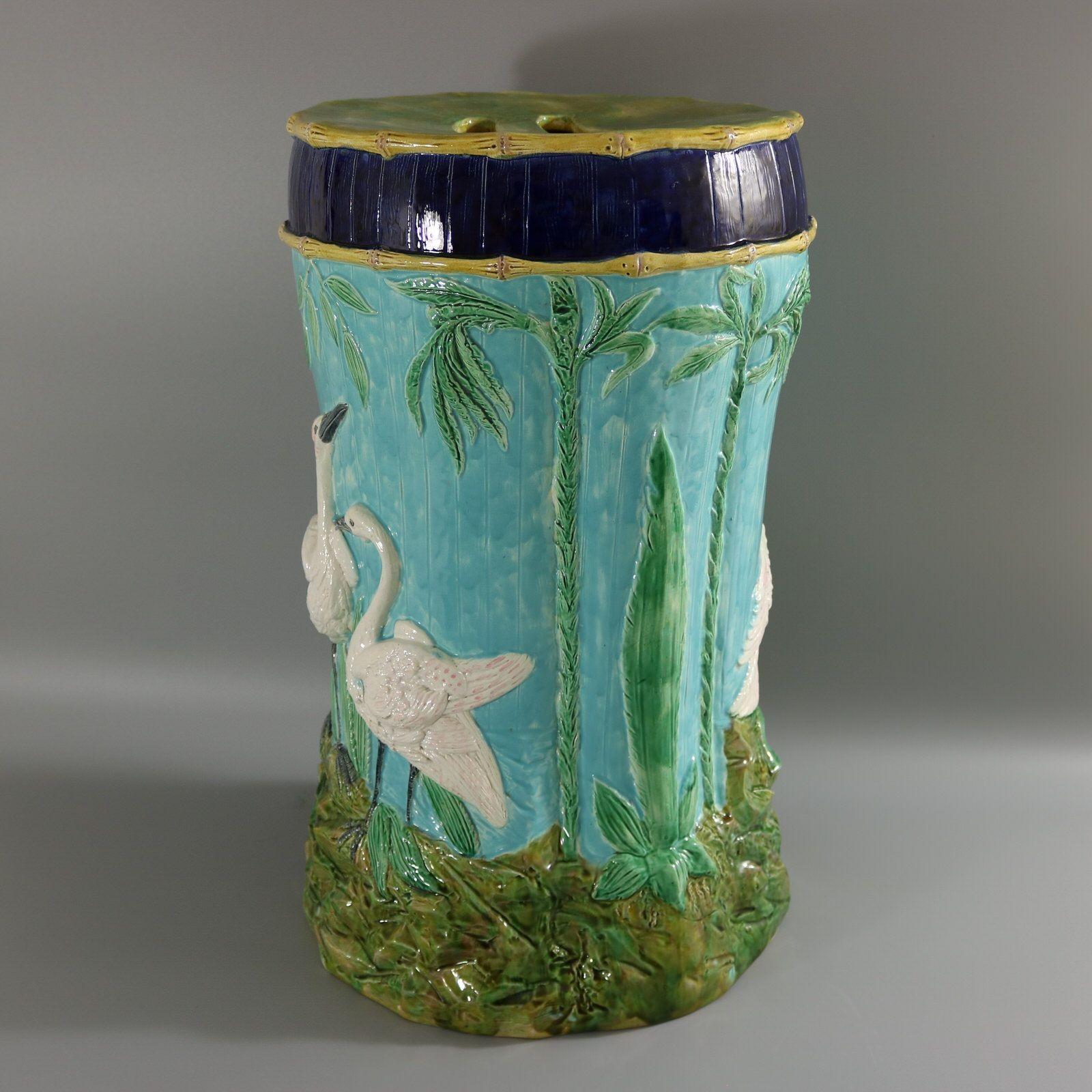 Thomas Forester Majolica Stork Garden Seat which features storks stood on rocky ground with bamboo decoration. Turquoise ground version. Colouration: turquoise, green, white, are predominant.