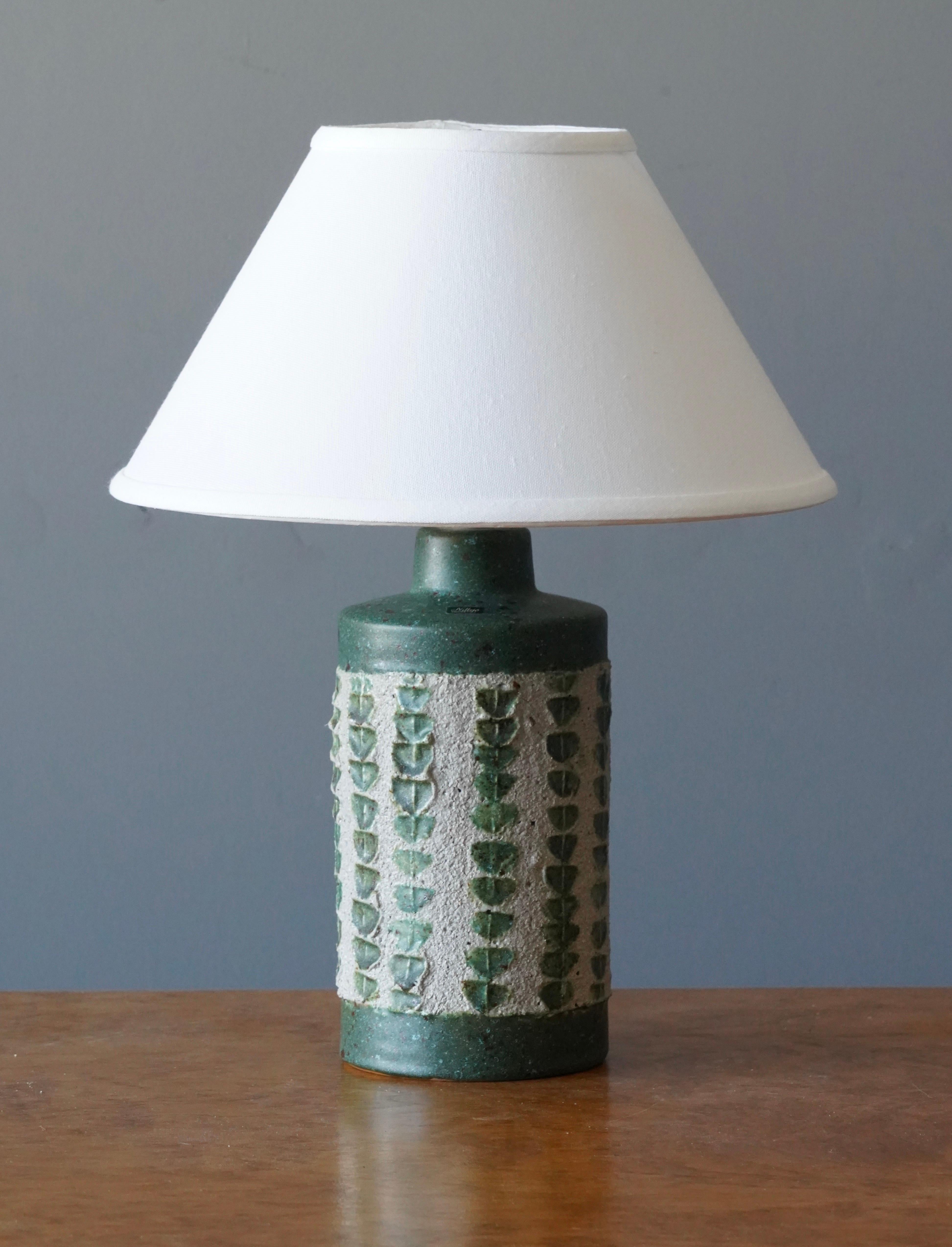 A table lamp designed by Thomas Hellström, produced by Nittsjö, Sweden, c. 1960s.

Features subtle incised decor and a incised details.

Sold without Lampshade. 

Measurement with shade: 16