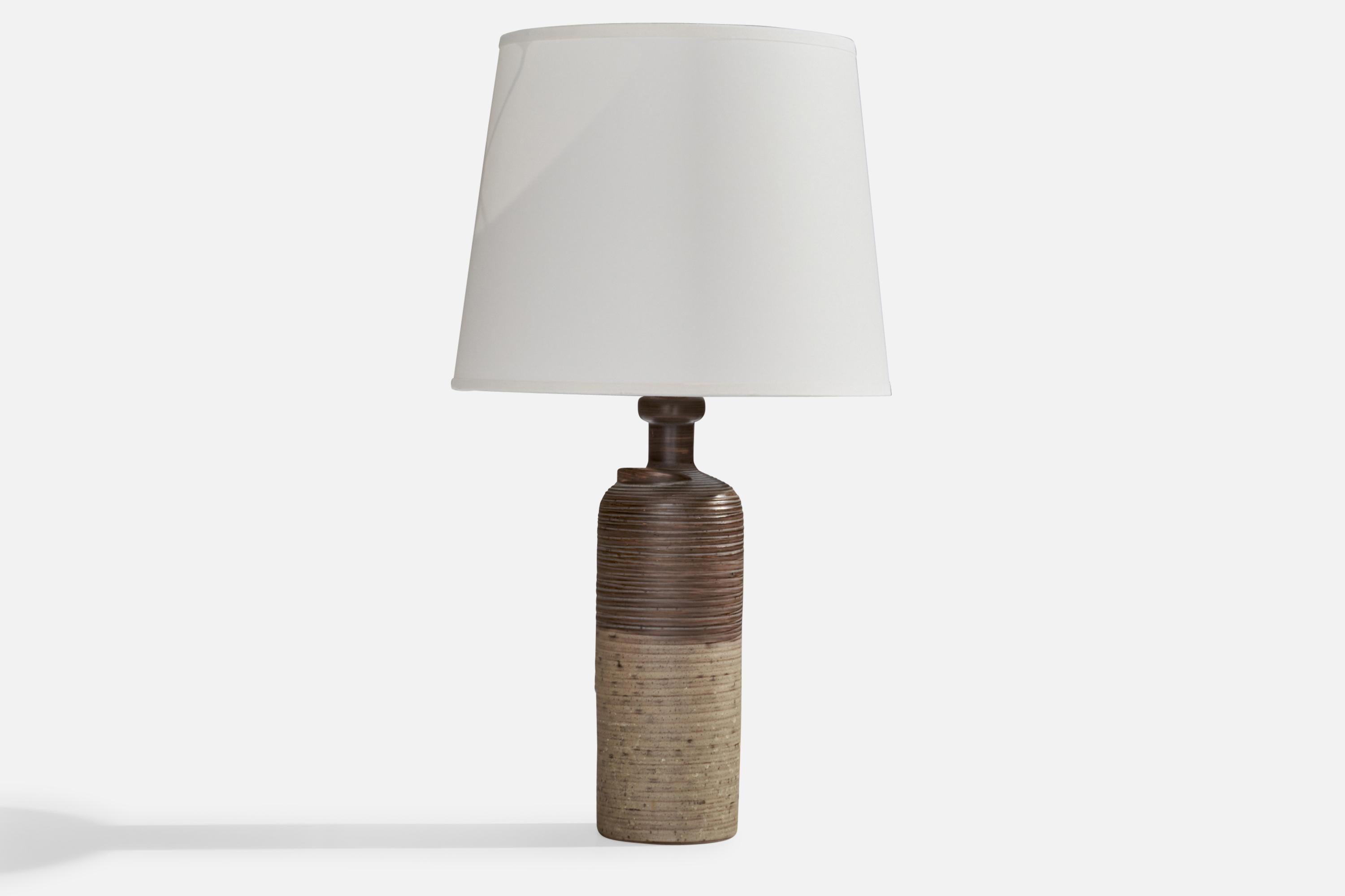 A grey-glazed incised ceramic table lamp designed by Thomas Hellström and produced by Nittsjö, Sweden, c. 1960s.

Dimensions of Lamp (inches): 12.65” H x 3.25”  Diameter
Dimensions of Shade (inches): 7” Top Diameter x 10” Bottom Diameter x 8”