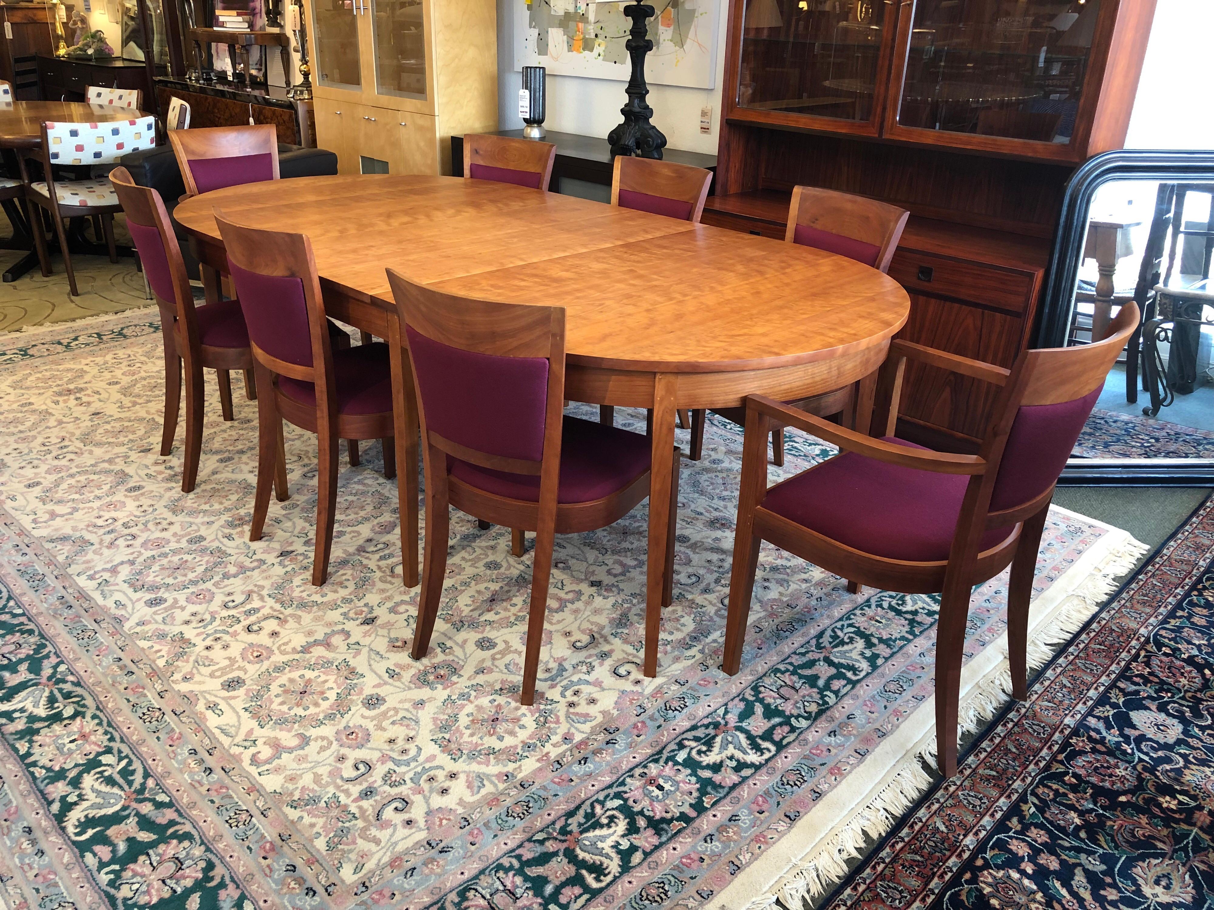 A Thomas Moser dining set complete with table with two leaves, and eight Harpswell chairs including two end chairs and six side chairs. The oval ring cherry dining table carries a handwritten signature on behalf of Thos. Moser Cabinetmakers in