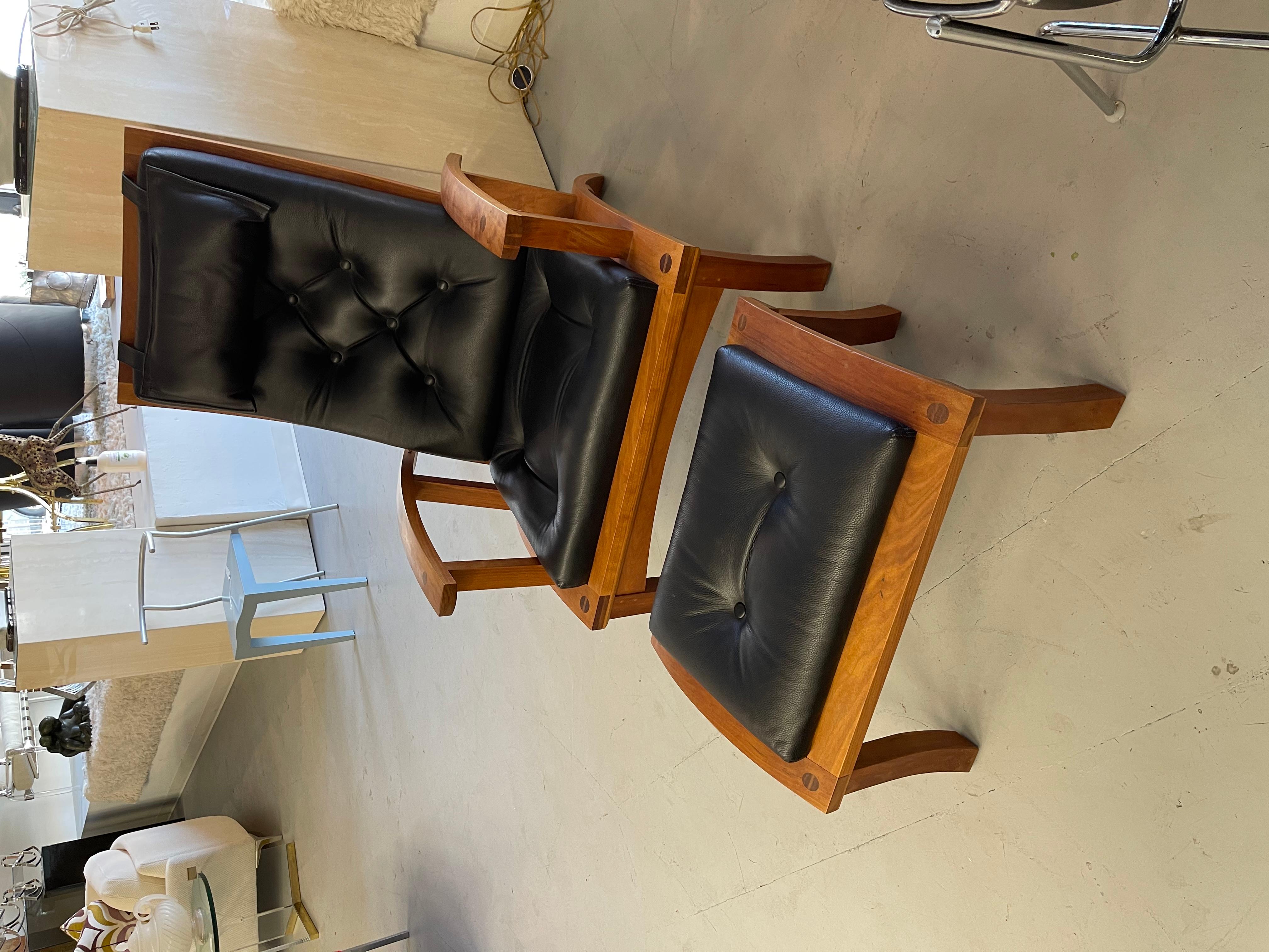 A nice Thomas Moser Lolling chair and ottoman with black leather cushions. Both pieces are signed and dated 2000. The chair is signed Michael Craig and the ottoman Ray Martin. There is a brass rod that adjusts the angle of the back. In good