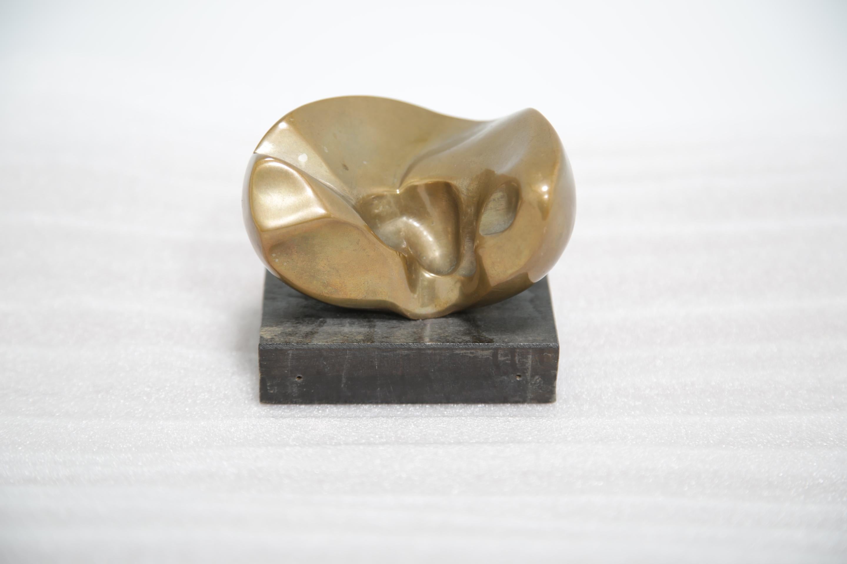 Thomas Nordbäck (1938-2019) - Escultor sueco. 

Aquí tenemos una pequeña pero llamativa escultura abstracta de bronce del artista sueco Thomas Nordbäck, montada sobre una base mínima de bloques de madera. La pieza tiene una elegancia tranquila: el