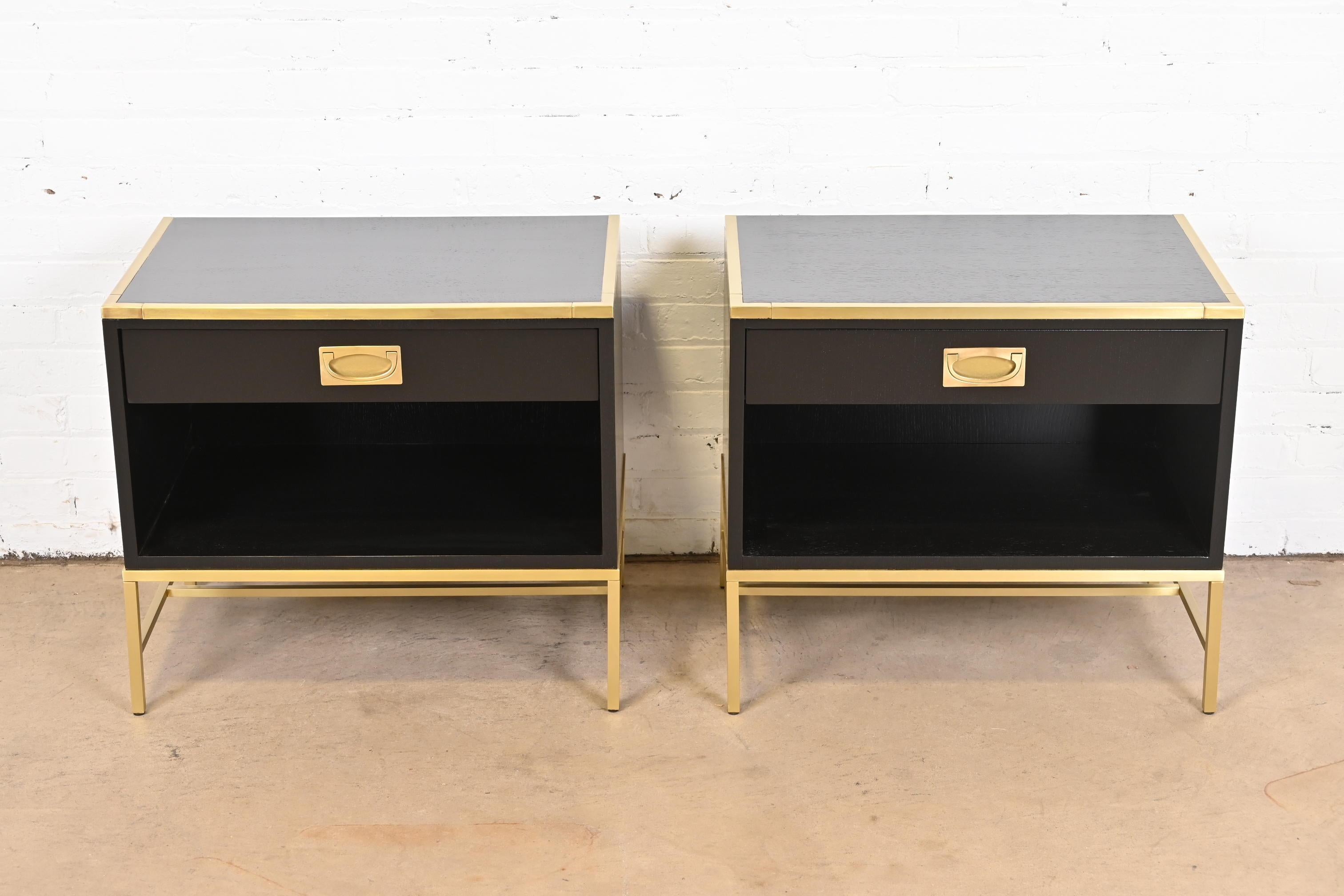An exceptional pair of Modern Hollywood Regency Campaign style nightstands or end tables

By Thomas Pheasant for Baker Furniture

USA, Early 21st Century

Black lacquered oak, with brass hardware, trim, and bases.

Measures: 25