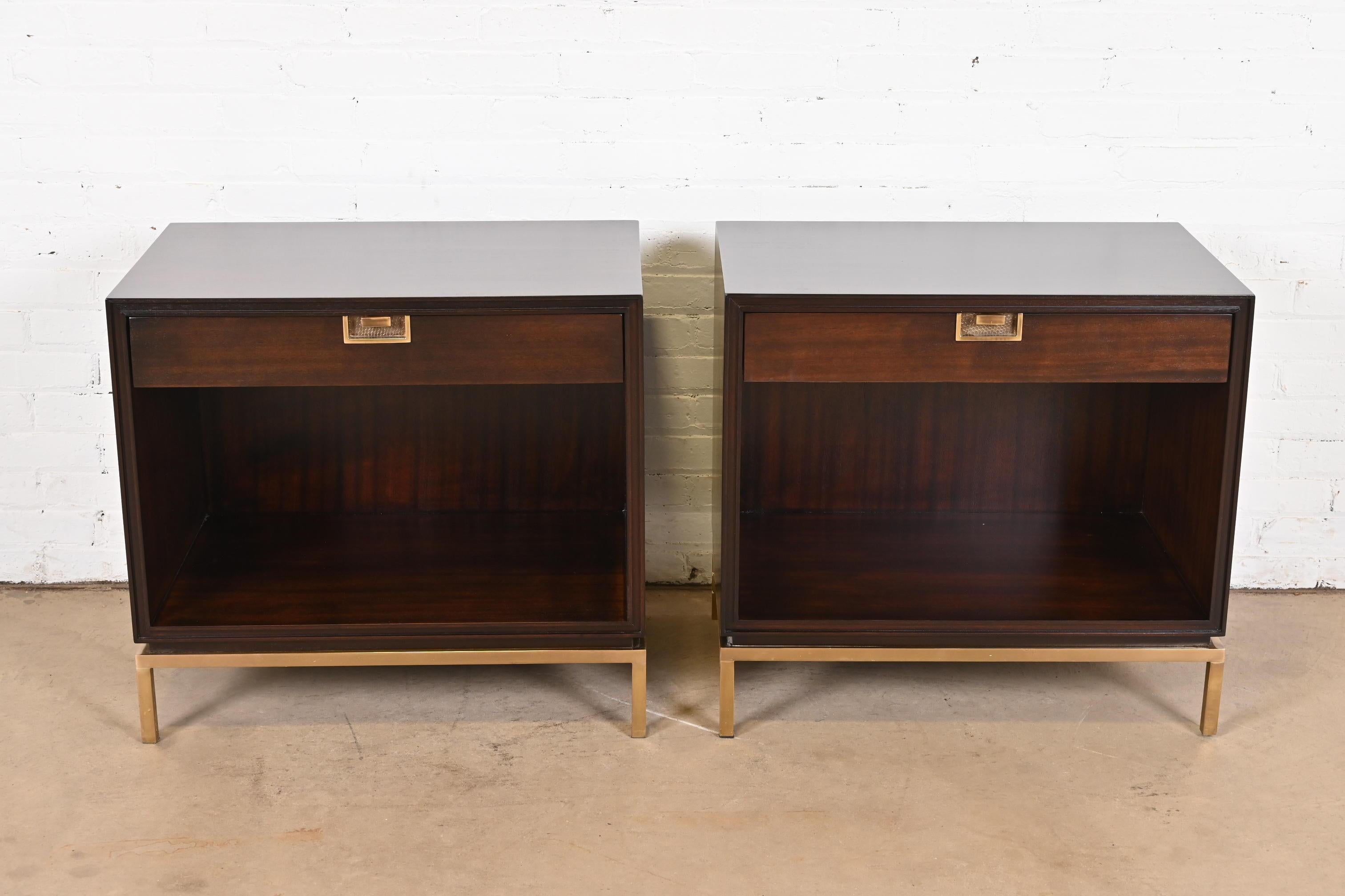 An exceptional pair of Modern Hollywood Regency Campaign style nightstands or end tables

By Thomas Pheasant for Baker Furniture

USA, Early 21st Century

Dark mahogany, with brass hardware and brass bases.

Measures: 28