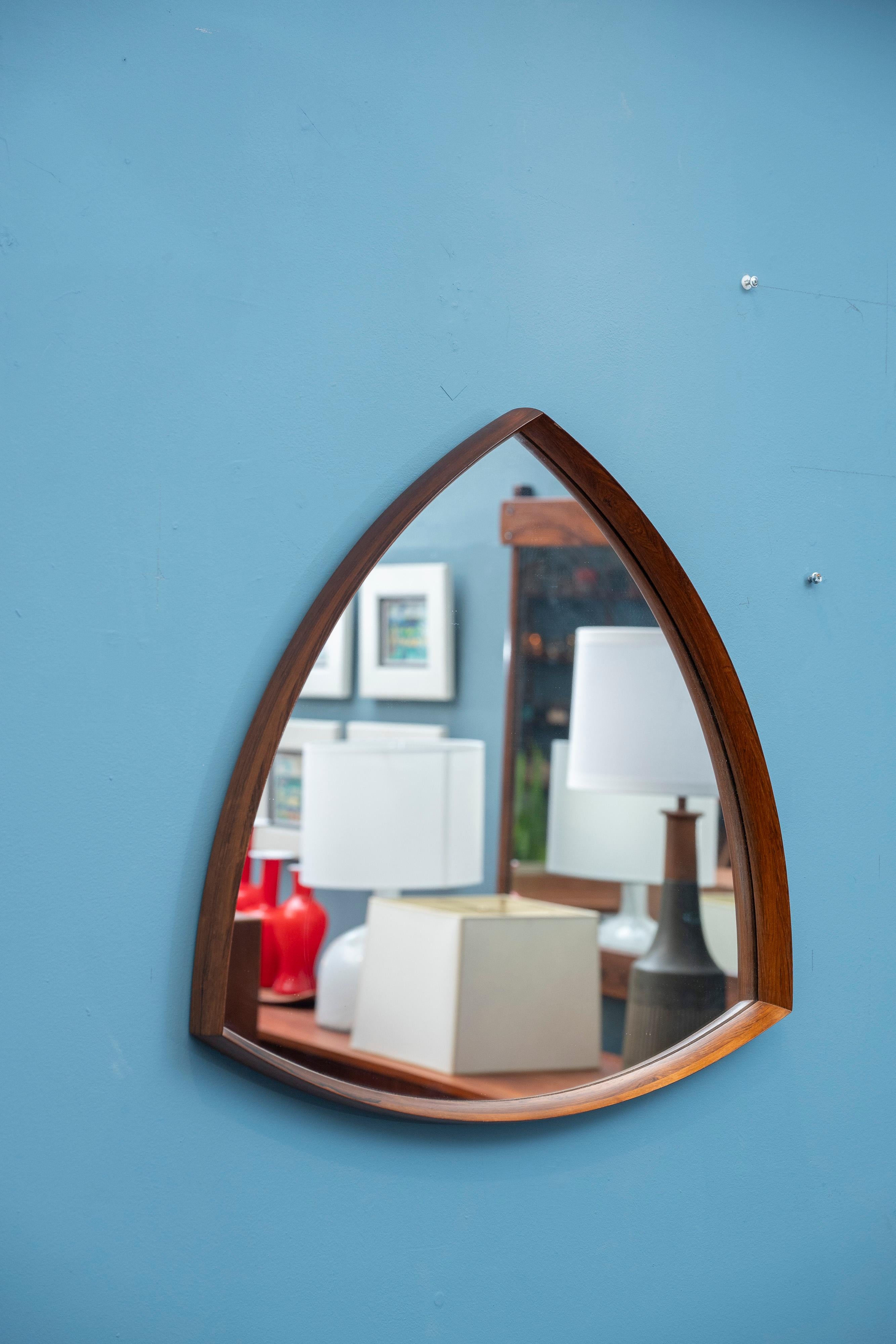 Thomas Poss Eferfolger design rosewood triangular form wall mirror. Refined design mirror that can be hung as a shield shape or as photographed a triangle. High quality construction and materials combined in a striking shape. Labeled and ready to