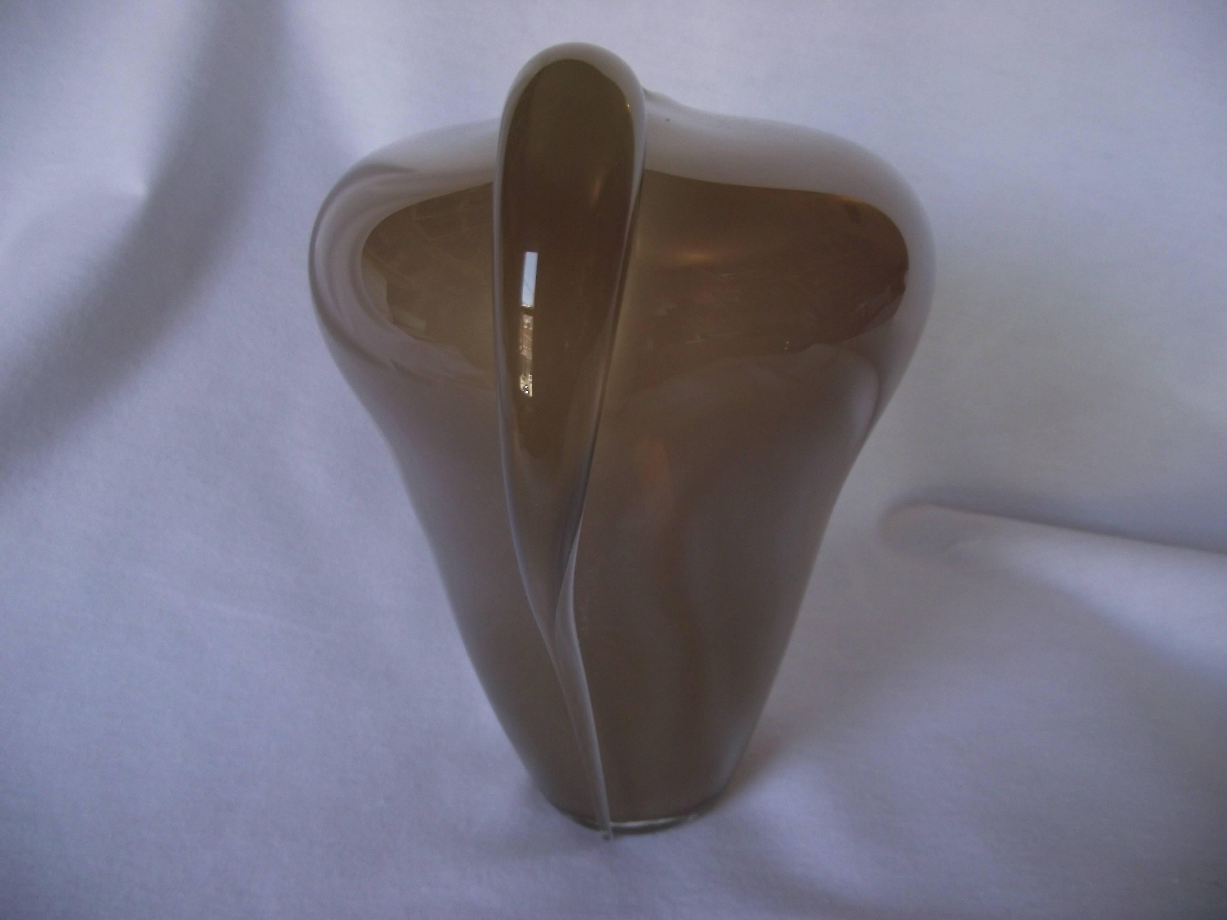 This beautiful mouth blown Art Deco vase is signed Thomas S Buechner III PS 02, 1982. The glass is a pale beige with clear wings.