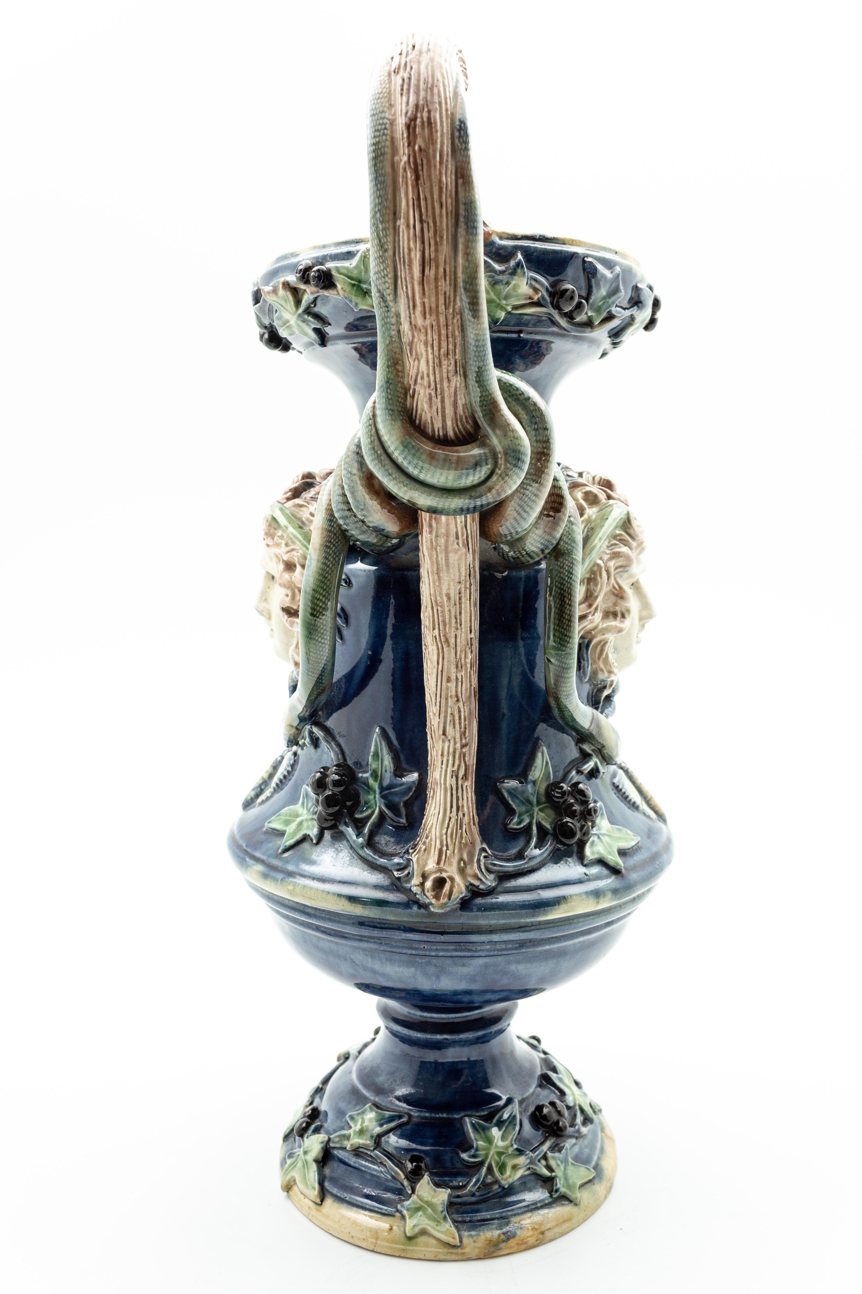 French Majolica Palissy Medusa vase made by Thomas Sargent with grape vine snake handles, circa 1890. This vase features Medusa's head on either side, as well as details of grape vines and moths. 15.5