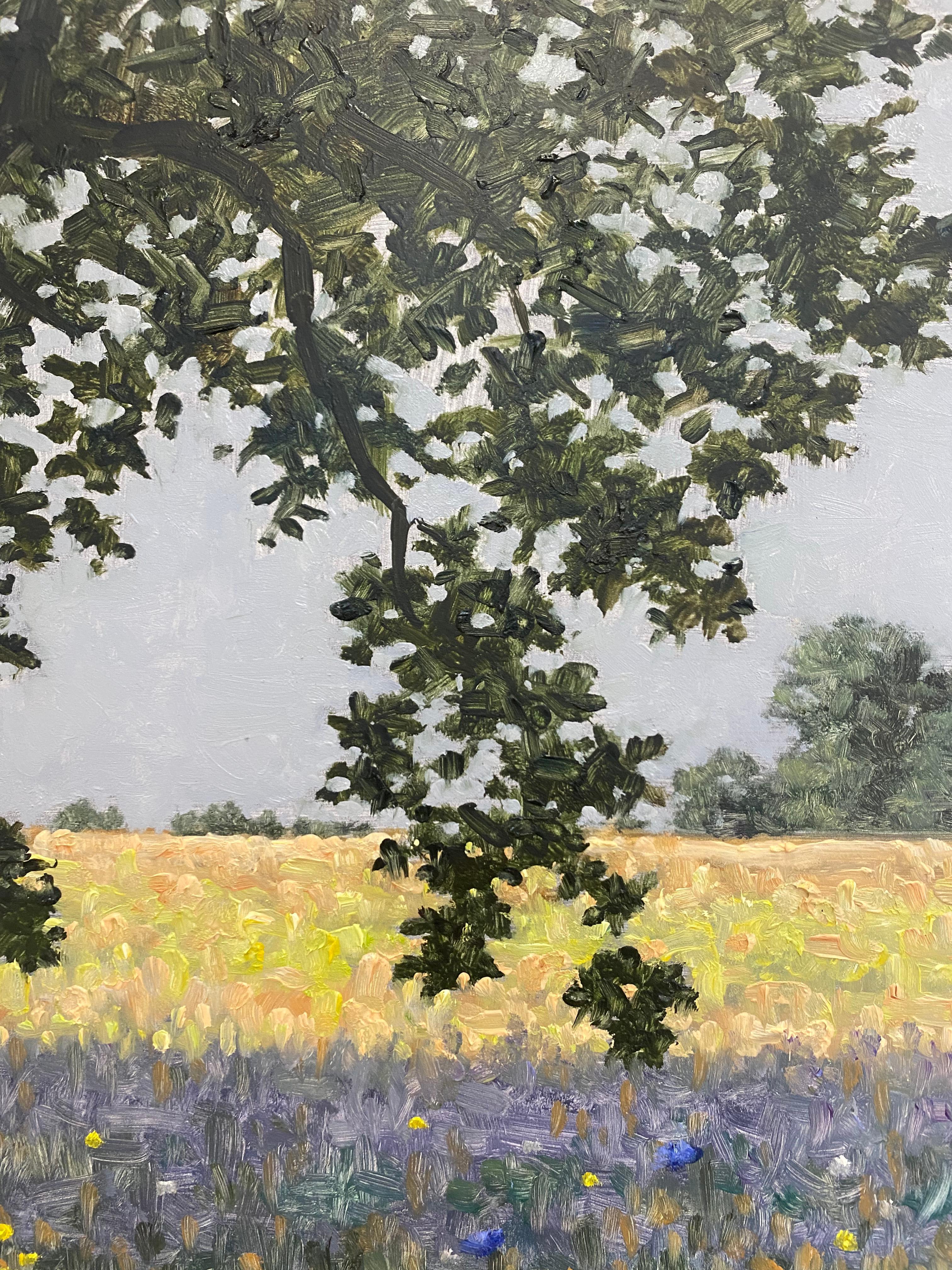 In questo paesaggio contemporaneo a olio su tavola, una tranquilla scena estiva di fiori blu-viola delicatamente dipinti in un campo erboso verde sotto un albero con foglie verde scuro cattura magnificamente l'atmosfera idilliaca di un campo di