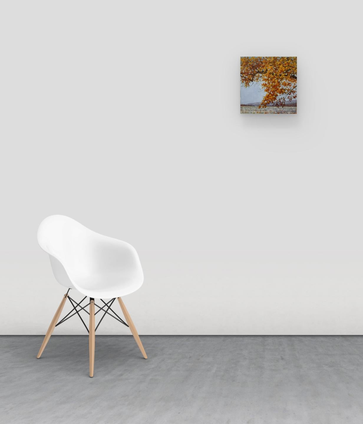 Contemporary landscape painting in oil on panel of a peaceful outdoor scene in late autumn with a tree with golden orange foliage with hints of deep red in a delicately painted, grassy field and low, rolling hills in the background, beautifully