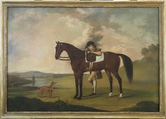 A groom with a saddled bay hunter and whippet, in an extensive landscape