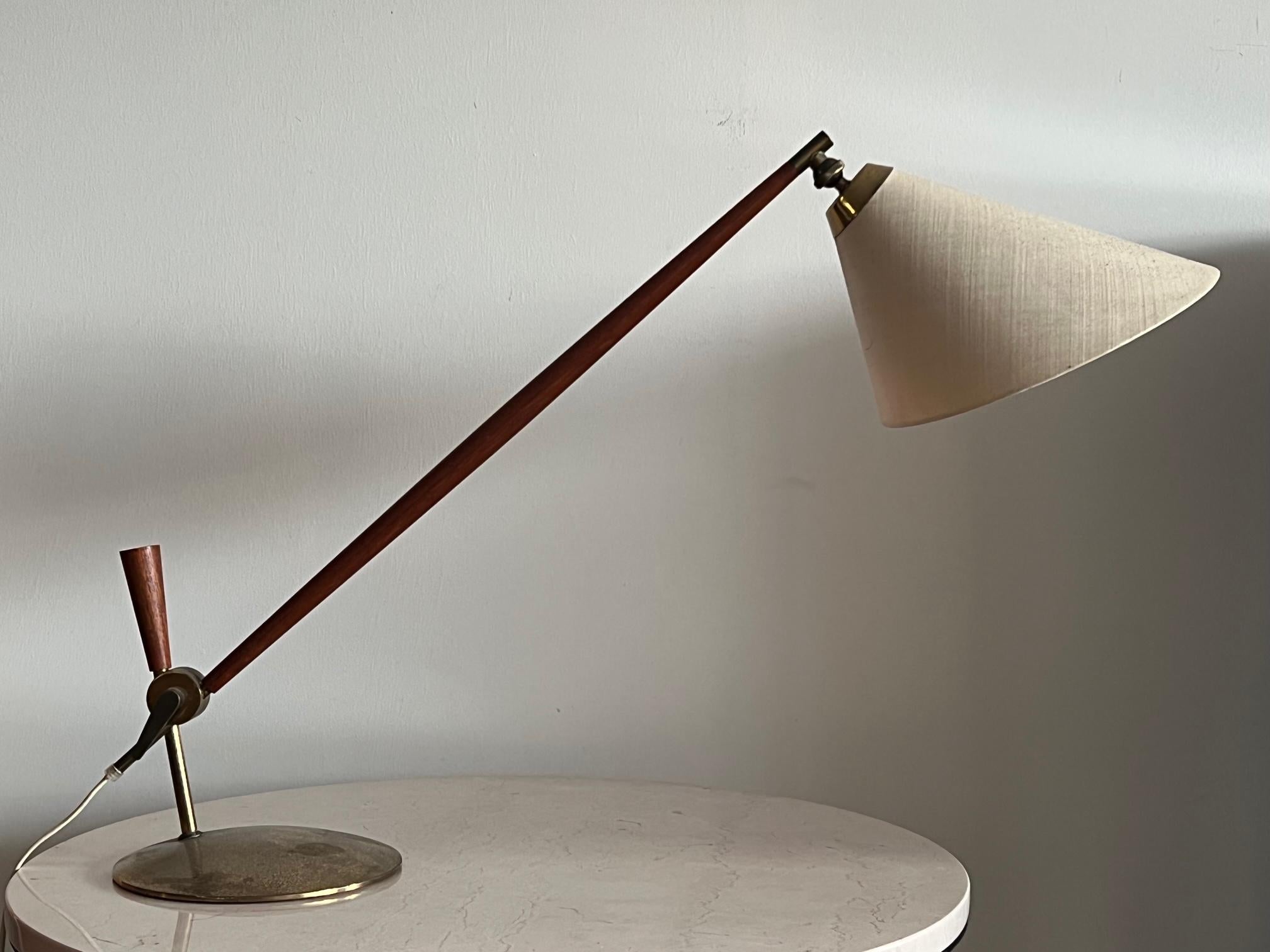 An unusual 1950's table lamp designed by Thomas Valentiner for Poul Dinesen. Brass and teak with original shade.
Brass has patina and oxidation.