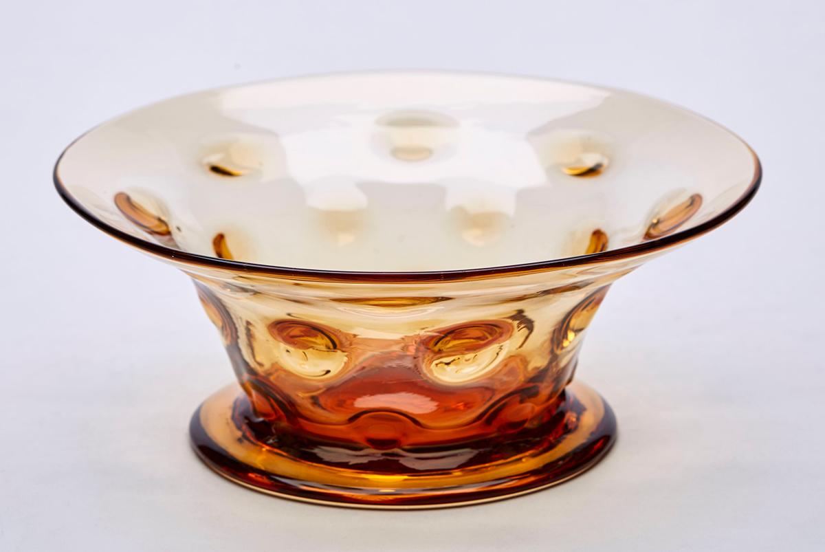 A stunning vintage midcentury Thomas Webb hand blown amber art glass bowl with a 'bulls eye' or knobbly design dating from around 1950. The bowl is of conical form with a splayed trumpet shaped rim and stands on a thick wide rounded foot with