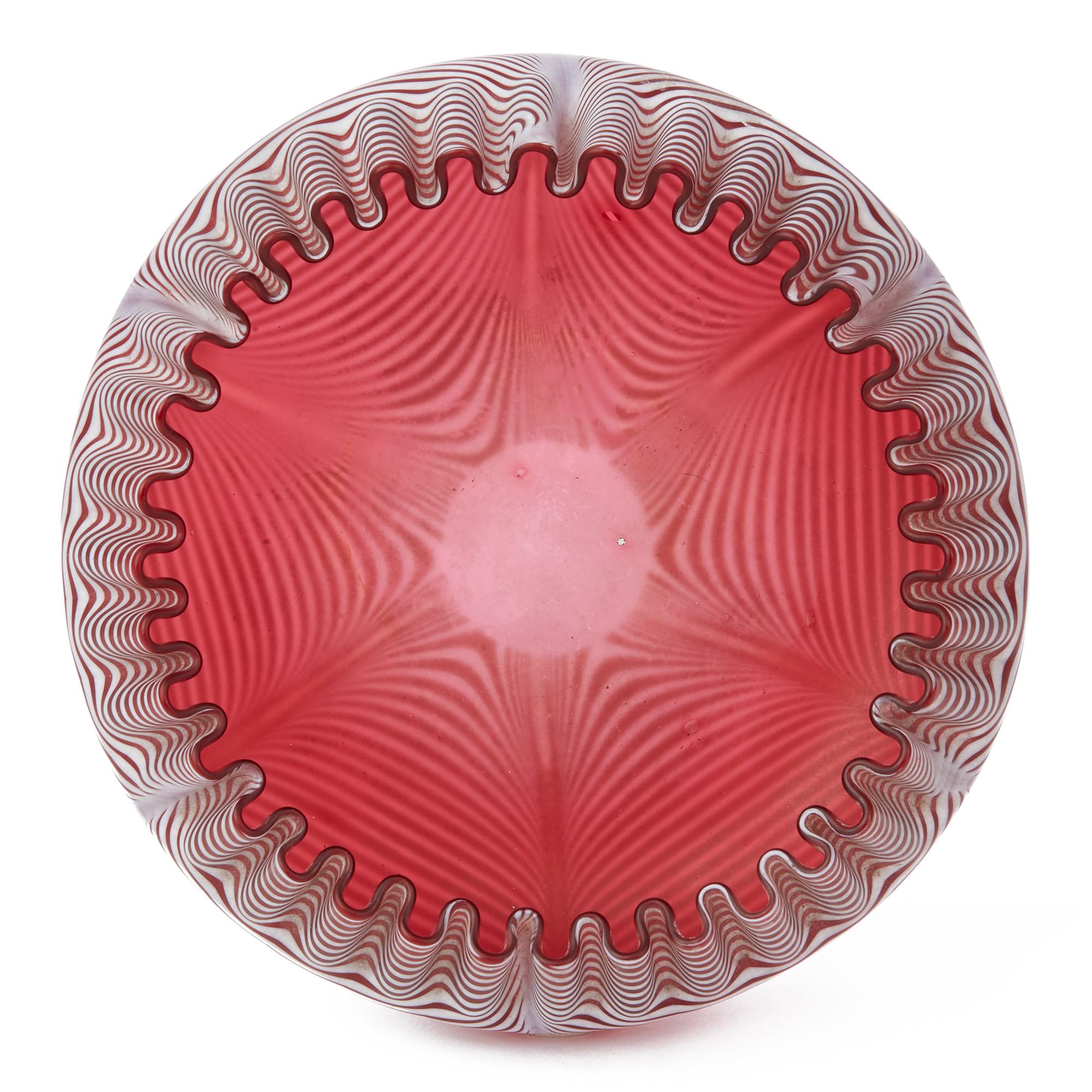 An exceptional antique cranberry glass verre moire bowl attributed to Thomas Webb and dating from circa 1890. The shallow rounded bowl has a fine and evenly crimped rim with Fine and even white patterned threading trailed through the cranberry glass