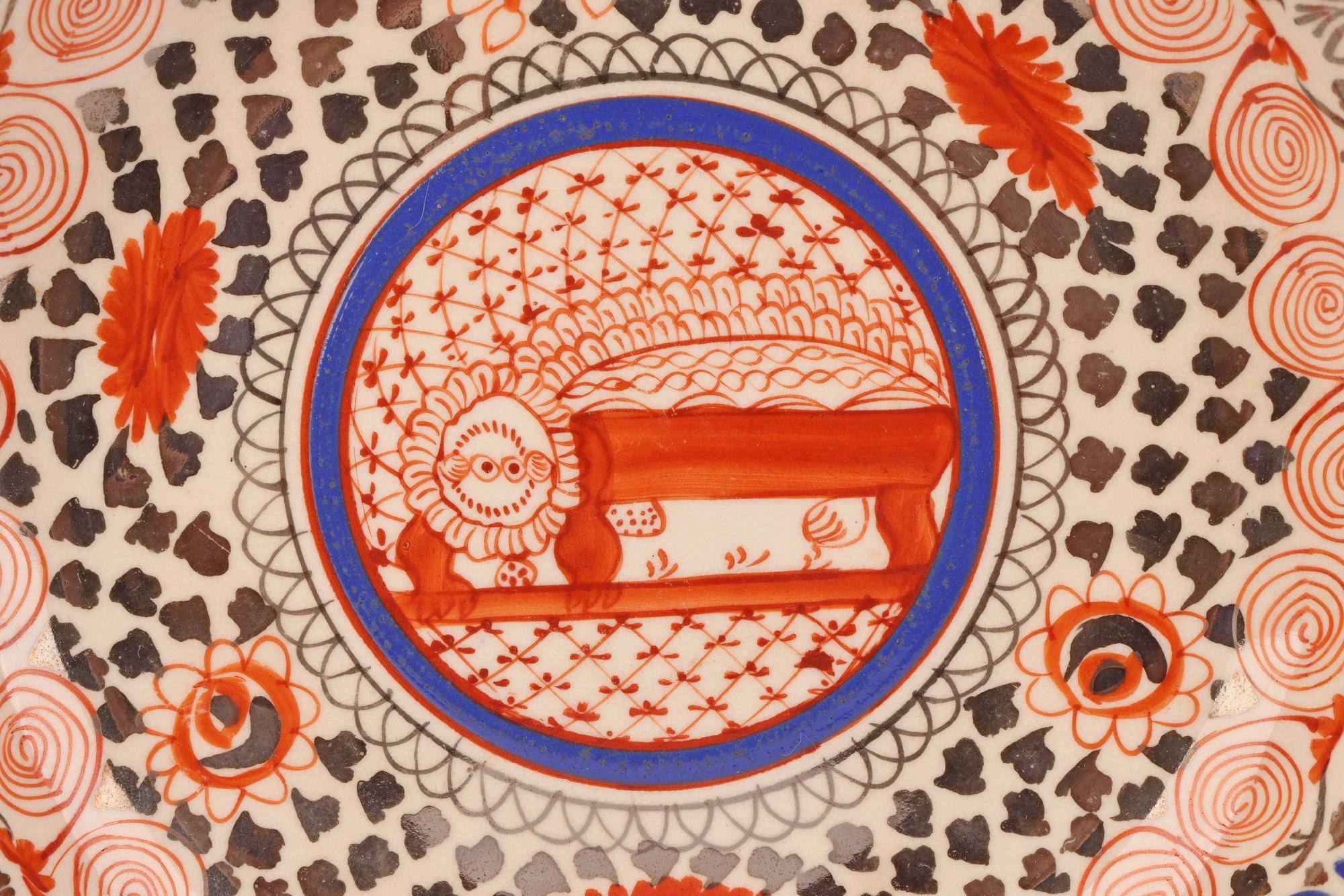 Eine seltene antike englische Teetasse und Untertasse aus Staffordshire-Porzellan, handdekoriert mit einem roten Löwen von Thomas Wolfe (Fabrik Z), aus der Zeit um 1810. Die Tasse hat eine breite runde Form mit einem geformten Seitenhenkel und ist