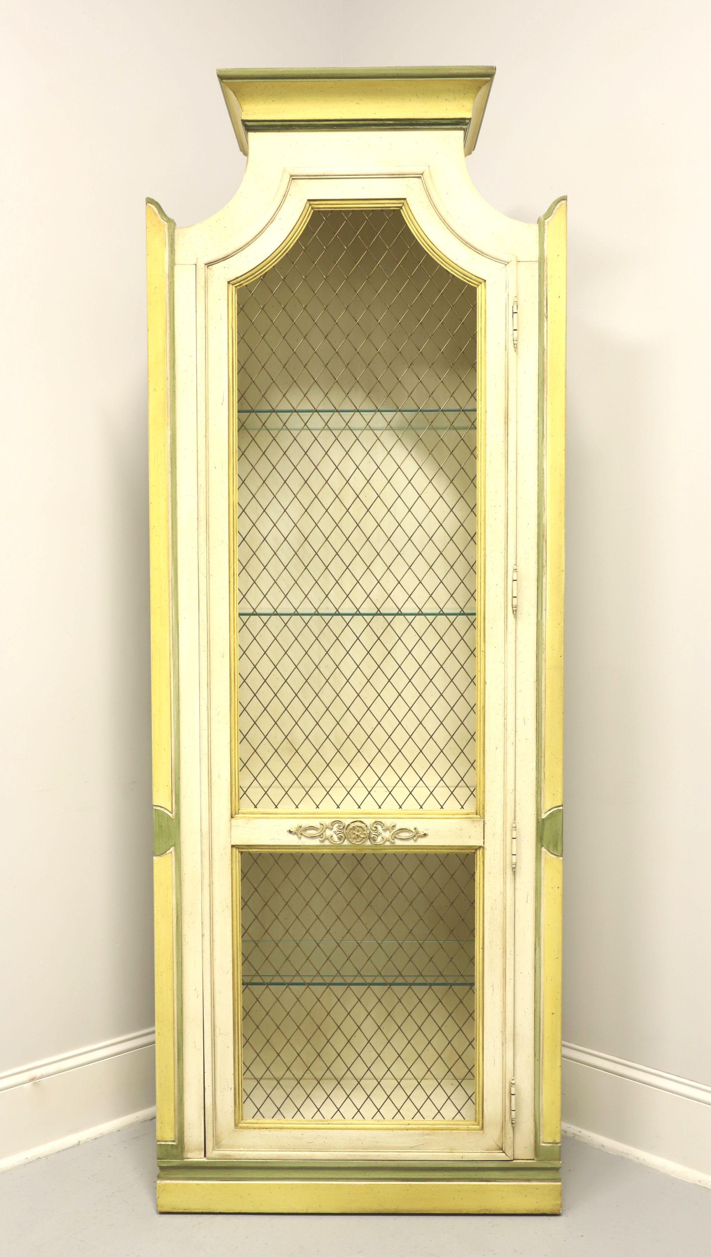 A Neoclassical style curio display cabinet by Thomasville. Solid hardwood painted antique white, yellow & green, pediment crown to top, decorative arched side columns, brass mesh and brass hardware. Features a single brass mesh covered door with