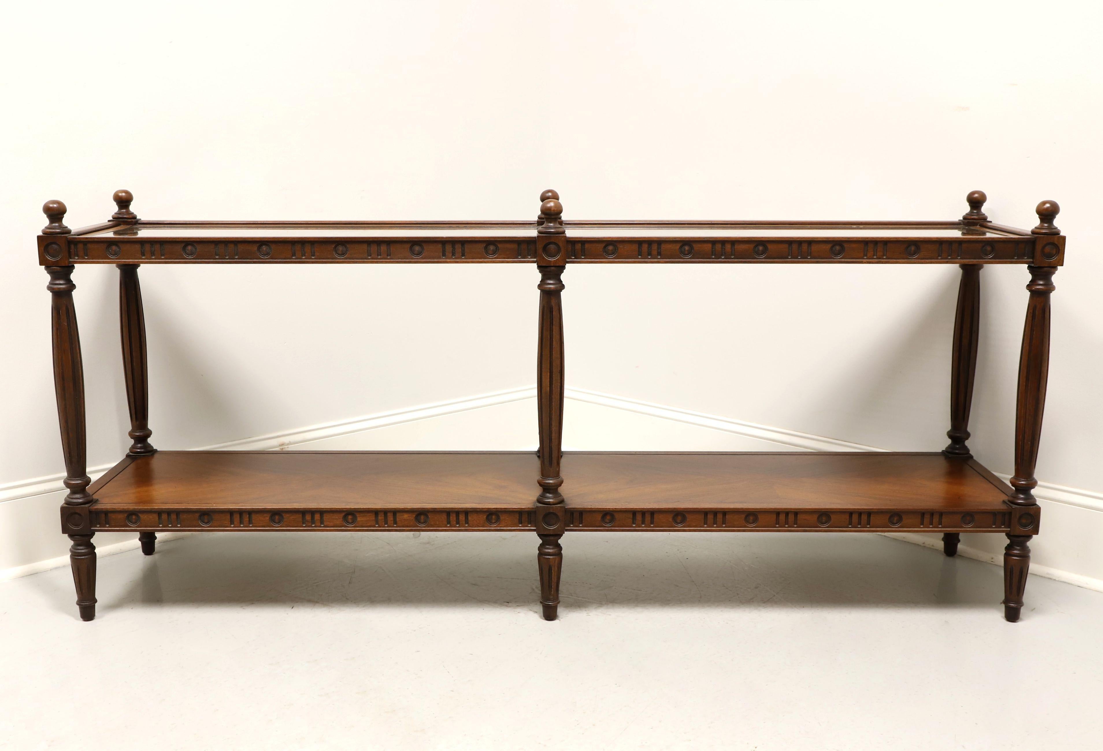 A Neoclassical style console table by Thomasville Furniture. Solid walnut, caned top with inserted glass coverings, finials capping the legs, carved aprons, lower tier shelf and round fluted legs. Made in North Carolina, USA, circa