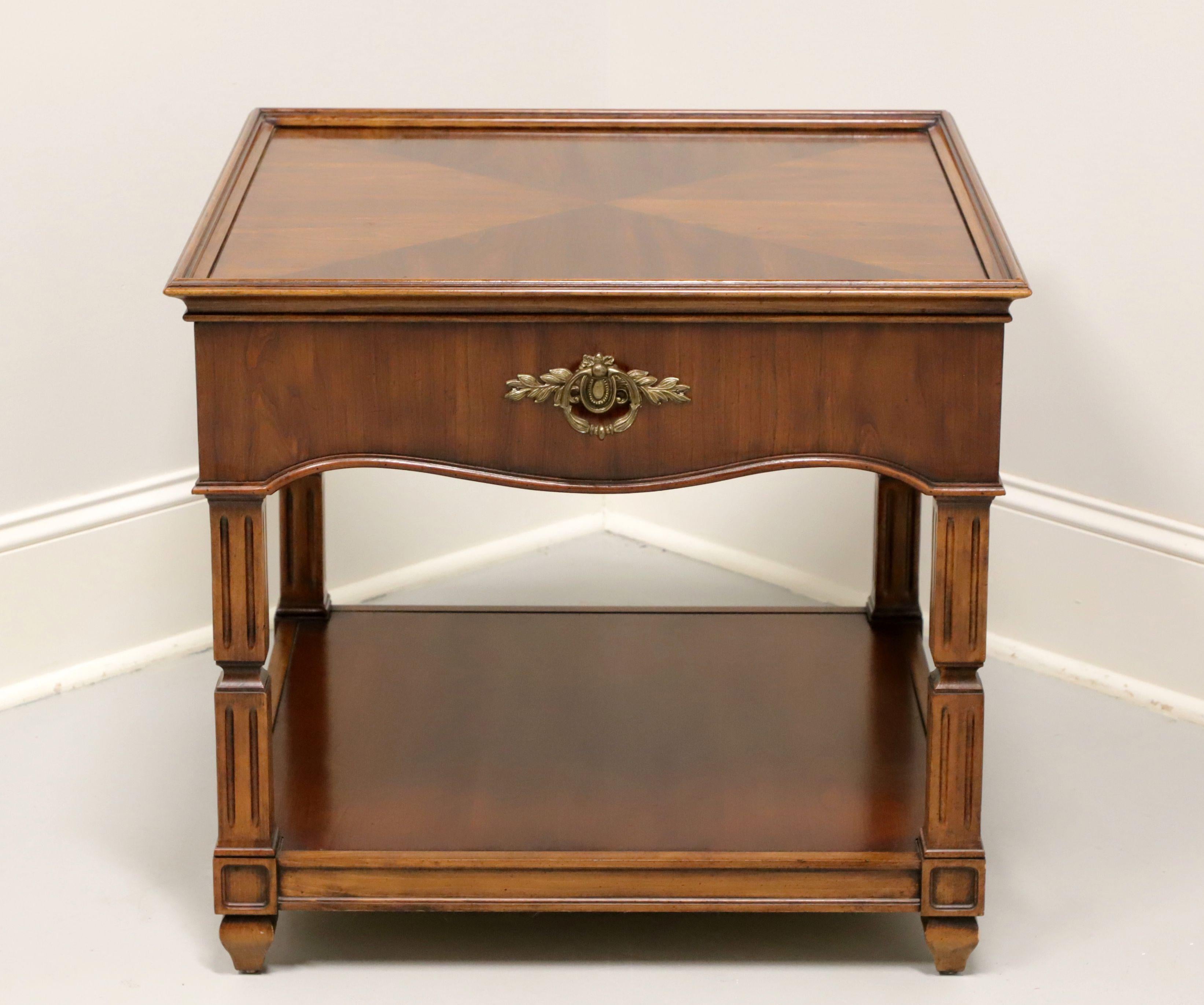 A French influenced square side table by Thomasville. Cherry wood with inlaid triangle parquetry design & low picture frame gallery edge to top, carved apron with brass handle to front side, a lower tier shelf, column-like legs, and spade feet. Made