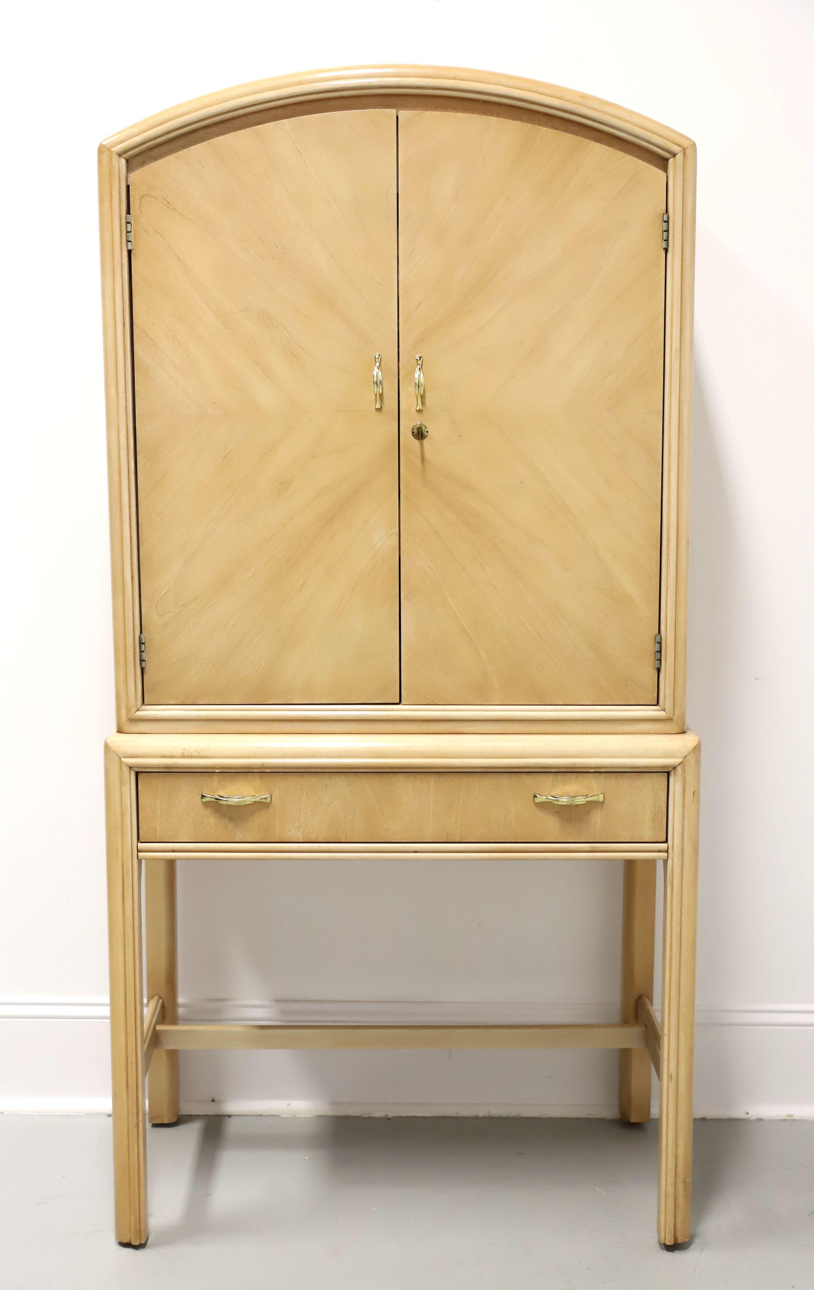 A Post-Modern style bar cabinet by Thomasville. Oak with a whitewashed finish, brass hardware, arched top, waterfall edges, bookmatched pattern to the doors, and is elevated on rounded edge straight legs with stretchers. Upper cabinet features the