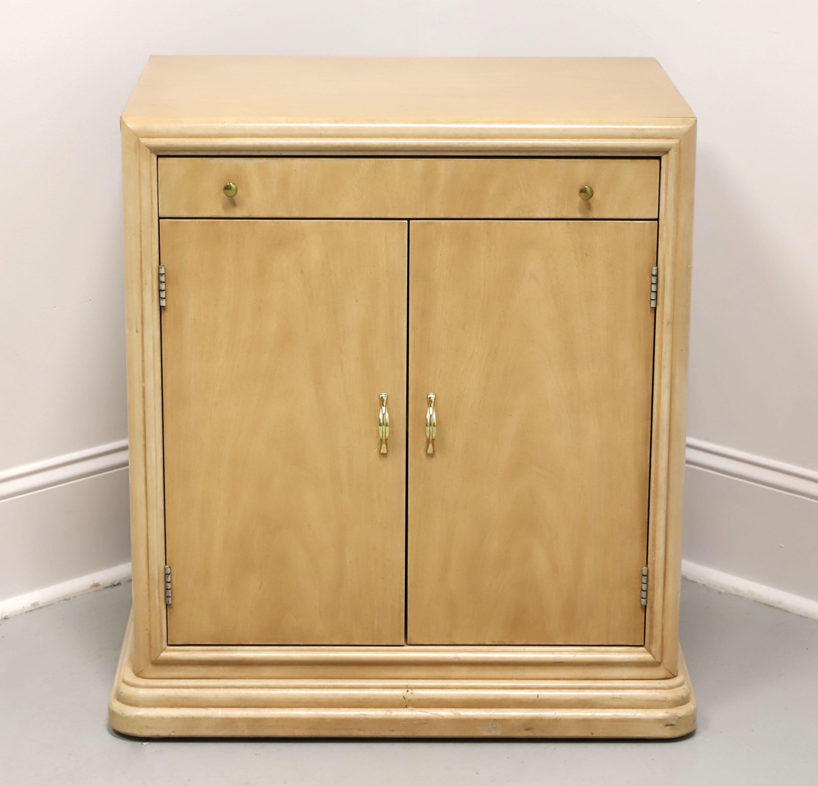 A Post-Modern style nightstand by Thomasville. Oak with a whitewashed finish, brass hardware, squared edge to the top, pull-out brushing slide, and a solid base. Features the pull-out brushing slide with black laminate top over a two door cabinet
