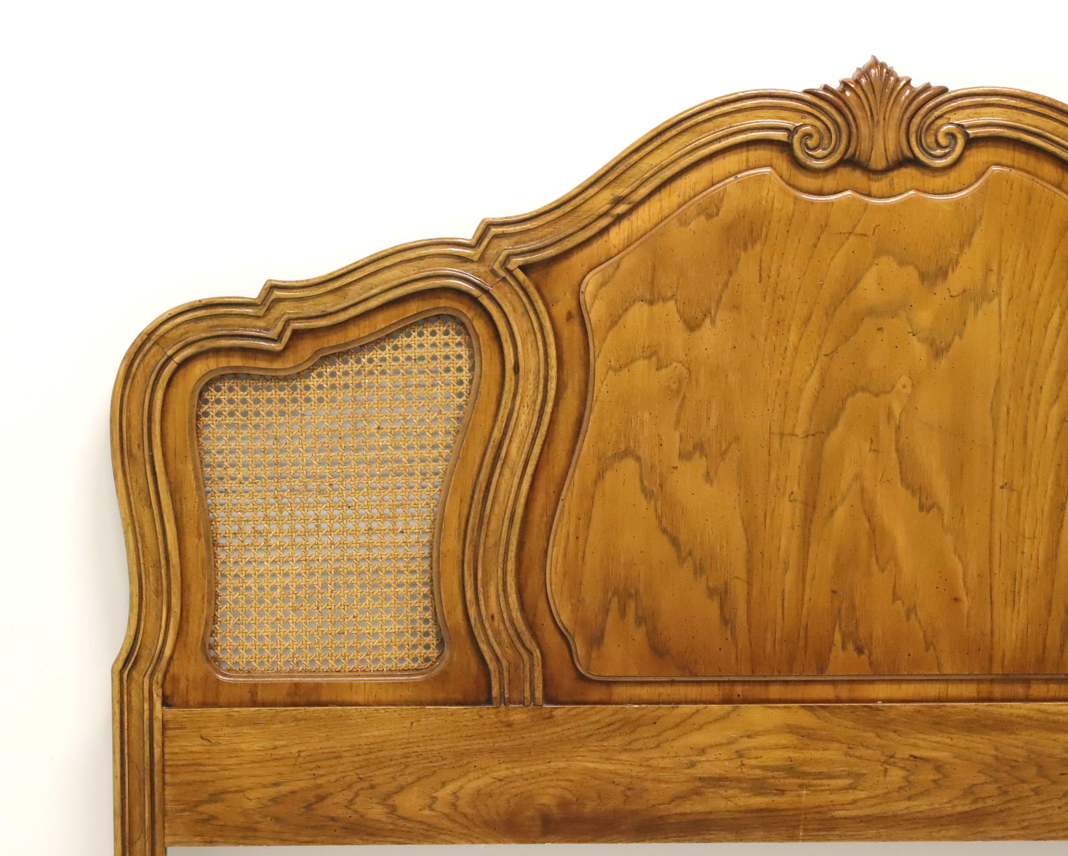 A French Country style queen size headboard by quality furniture maker Thomasville. Oak with caning and curvy French styling. Made in North Carolina, USA, in the late 20th Century. 

Style #: 11411-435

Measures: 61 W 1.5 D 52.5 H

Exceptionally