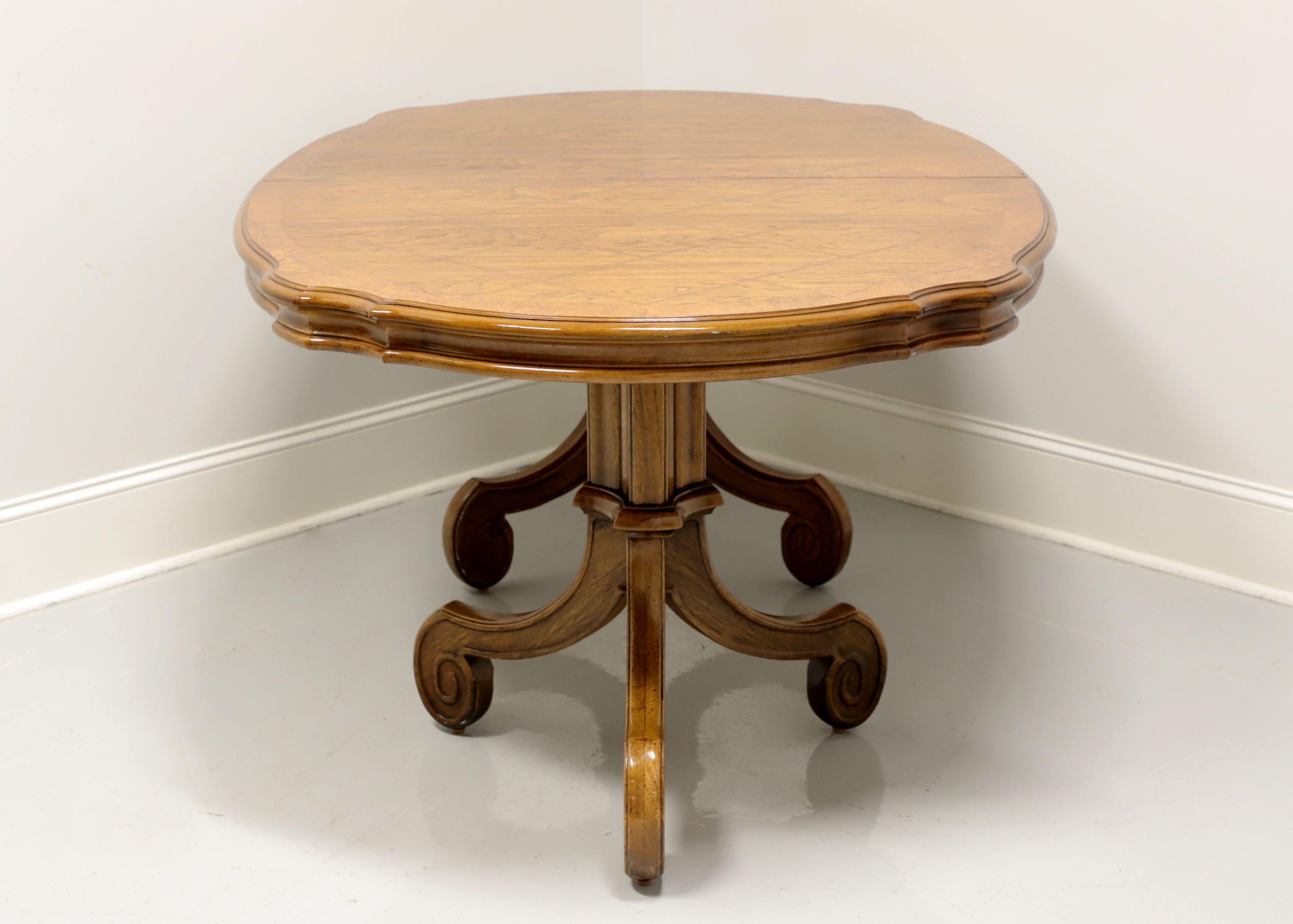 A Mediterranean style oval dining table by Thomasville, from their Ceremony Collection. Walnut with top surface featuring a parquet pattern and burl banding. Double pedestals with three scroll like legs. Metal expansion sliders. Includes two