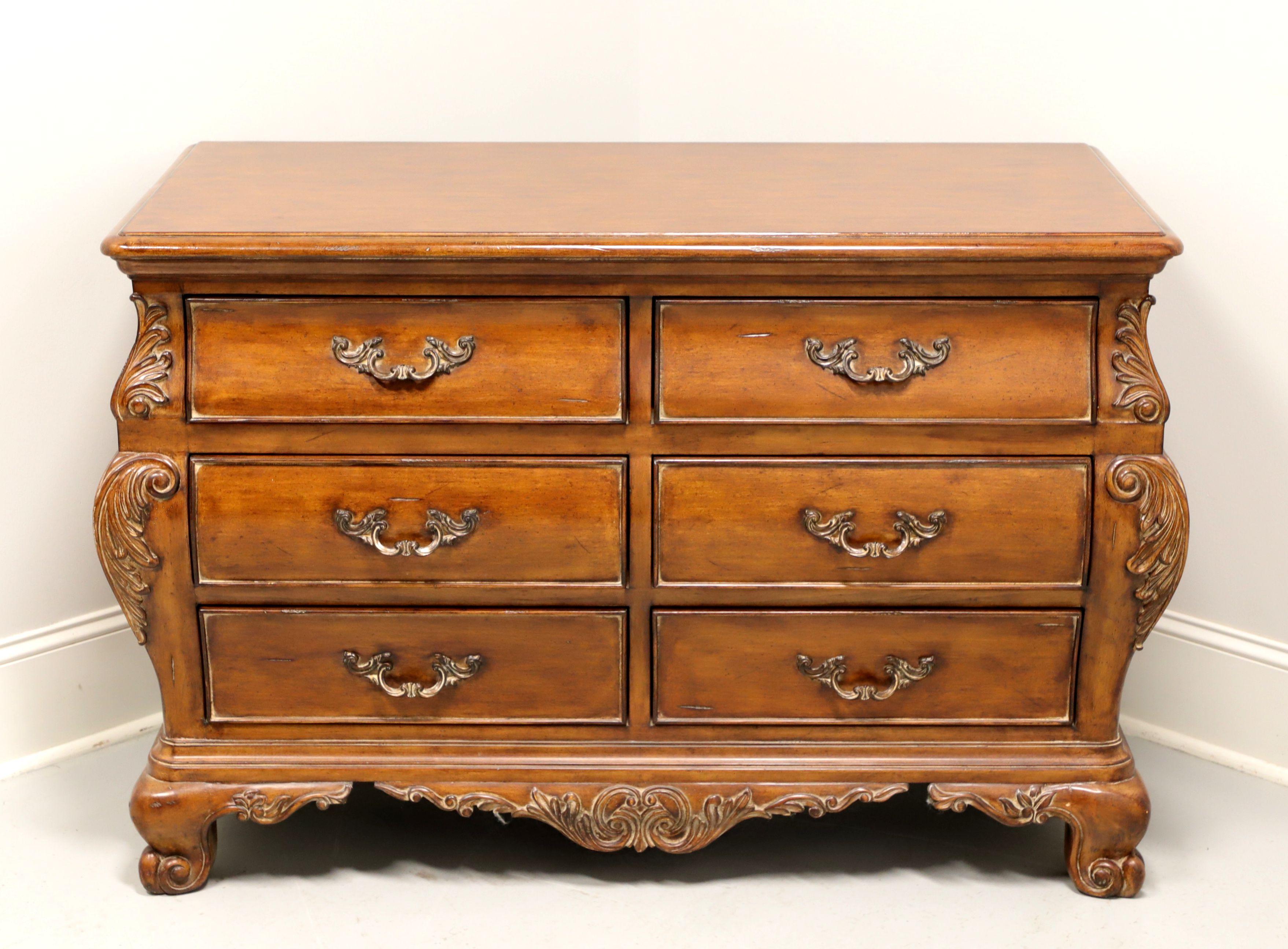 A double dresser in the French Country style by Thomasville, from their Chateau Provence Collection. Walnut with brass hardware, a slightly distressed finish, ogee edge to top, decoratively carved contoured sides with acanthus leaves, carved apron