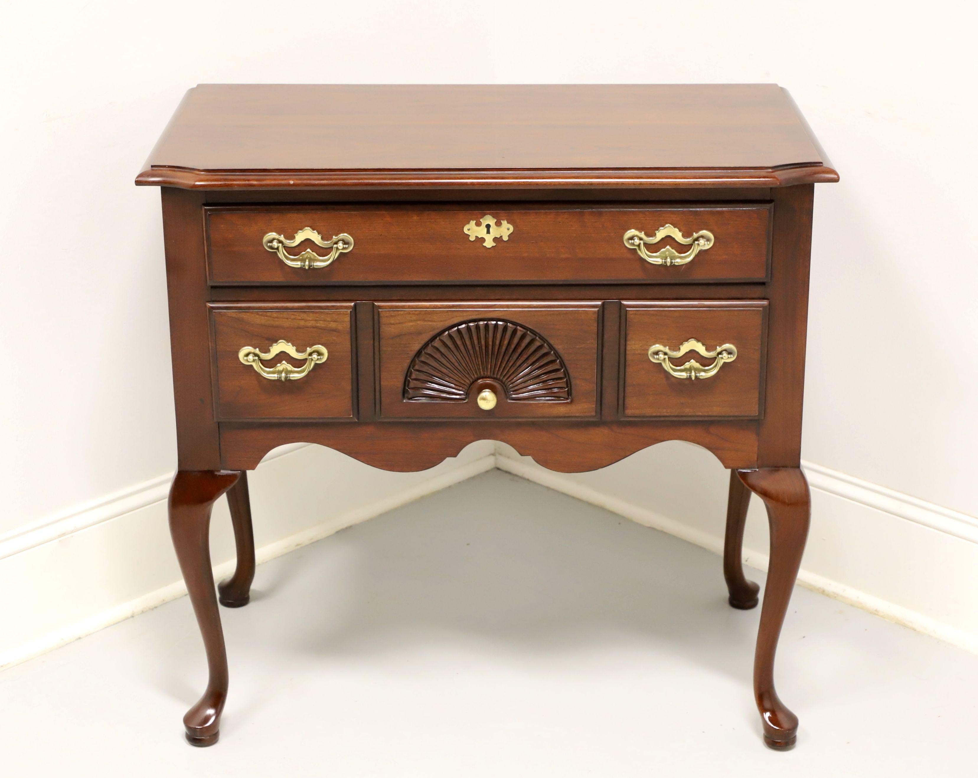 A Queen Anne style lowboy chest by Thomasville. Cherry with brass hardware, carved apron, cabriole legs and pad feet. Features one upper over three lower dovetail drawers, upper has faux keyhole escutcheon and center lower with carved fan. Made in