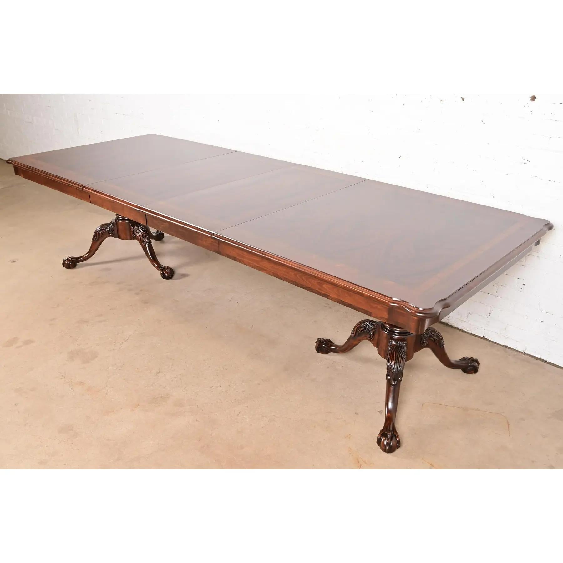 Exceptionnelle table de salle à manger à rallonge de style Chippendale ou géorgien

Par Thomasville

USA, Circa 1980

Magnifique plateau en acajou flammé assorti à un livre, avec bandes en bois satiné, et pieds en acajou massif sculpté avec pieds en