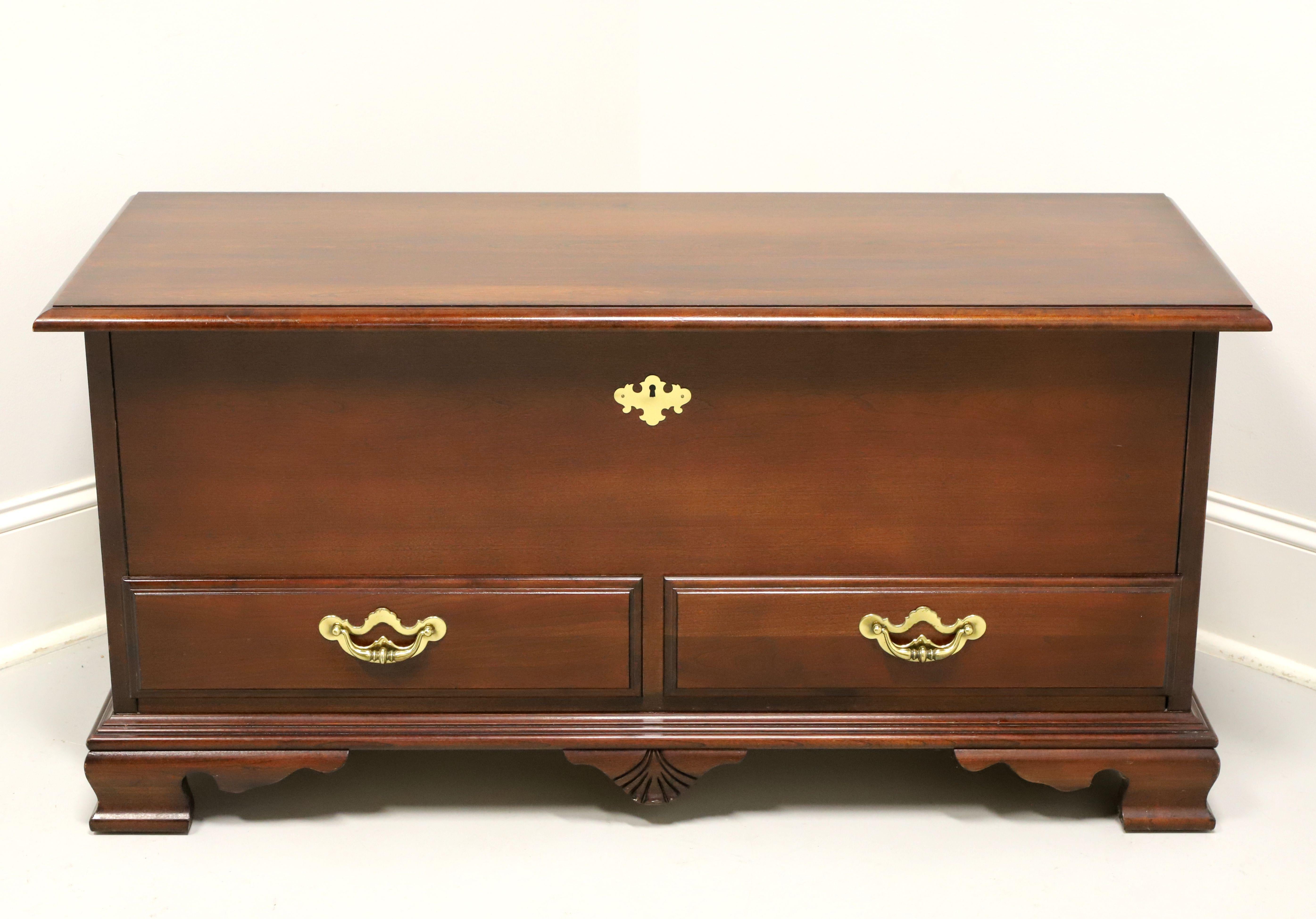 A Chippendale style blanket chest by Thomasville, from their Collectors Cherry Collection. Cherry wood with brass hardware, bevel edge to the lid top, faux drawer fronts, faux keyhole escutcheon, and ogee bracket feet. Features an ample cedar lined
