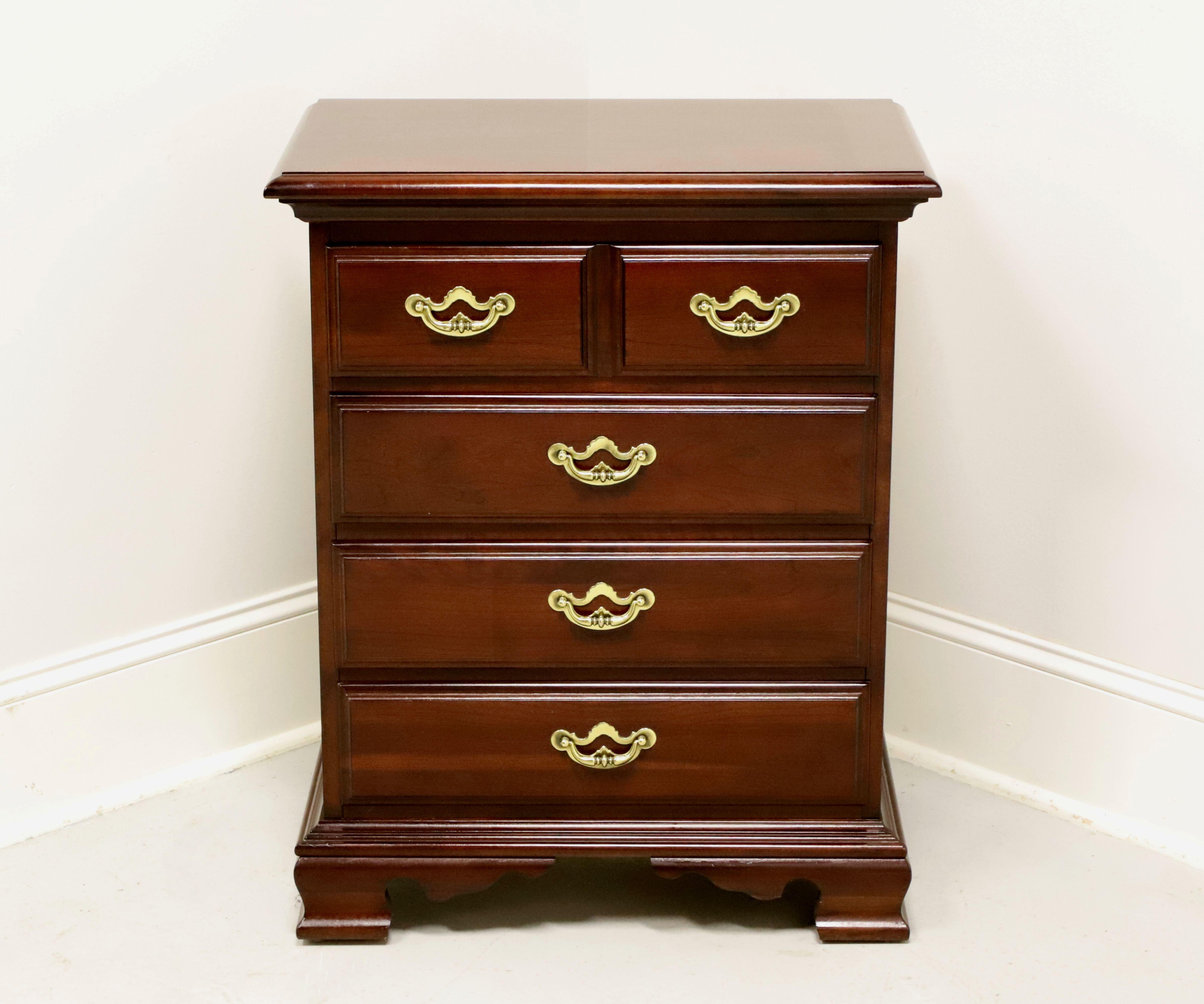 A Chippendale style bedside chest by Thomasville, from their Collectors Cherry Collection. Cherry wood with brass hardware, bevel edge top, raised drawer fronts, and ogee bracket feet. Features four drawers of dovetail construction. Made in North