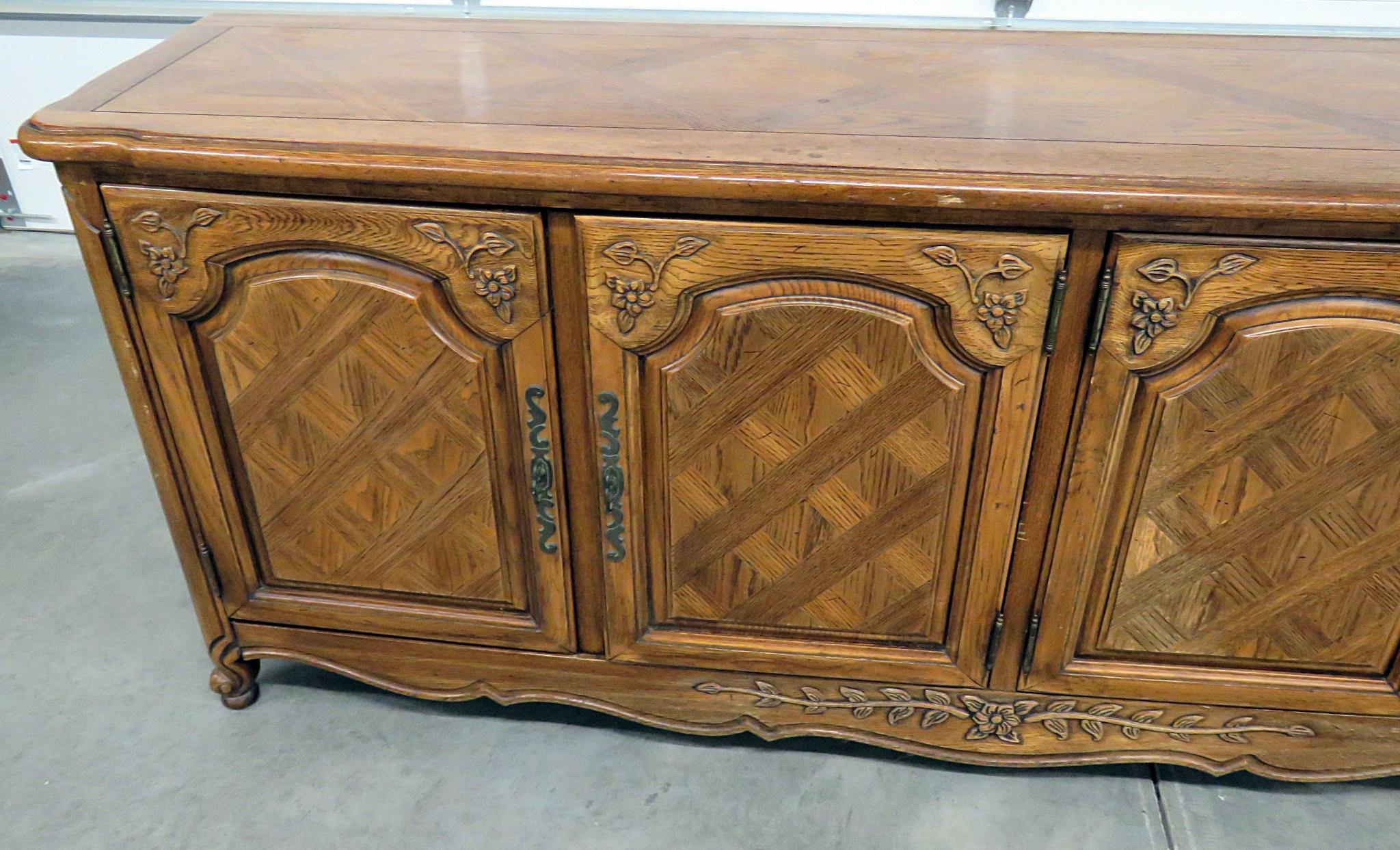 Thomasville Country French style sideboard with 2 doors that contain 3 drawers and 2 doors that contain 1 shelf.