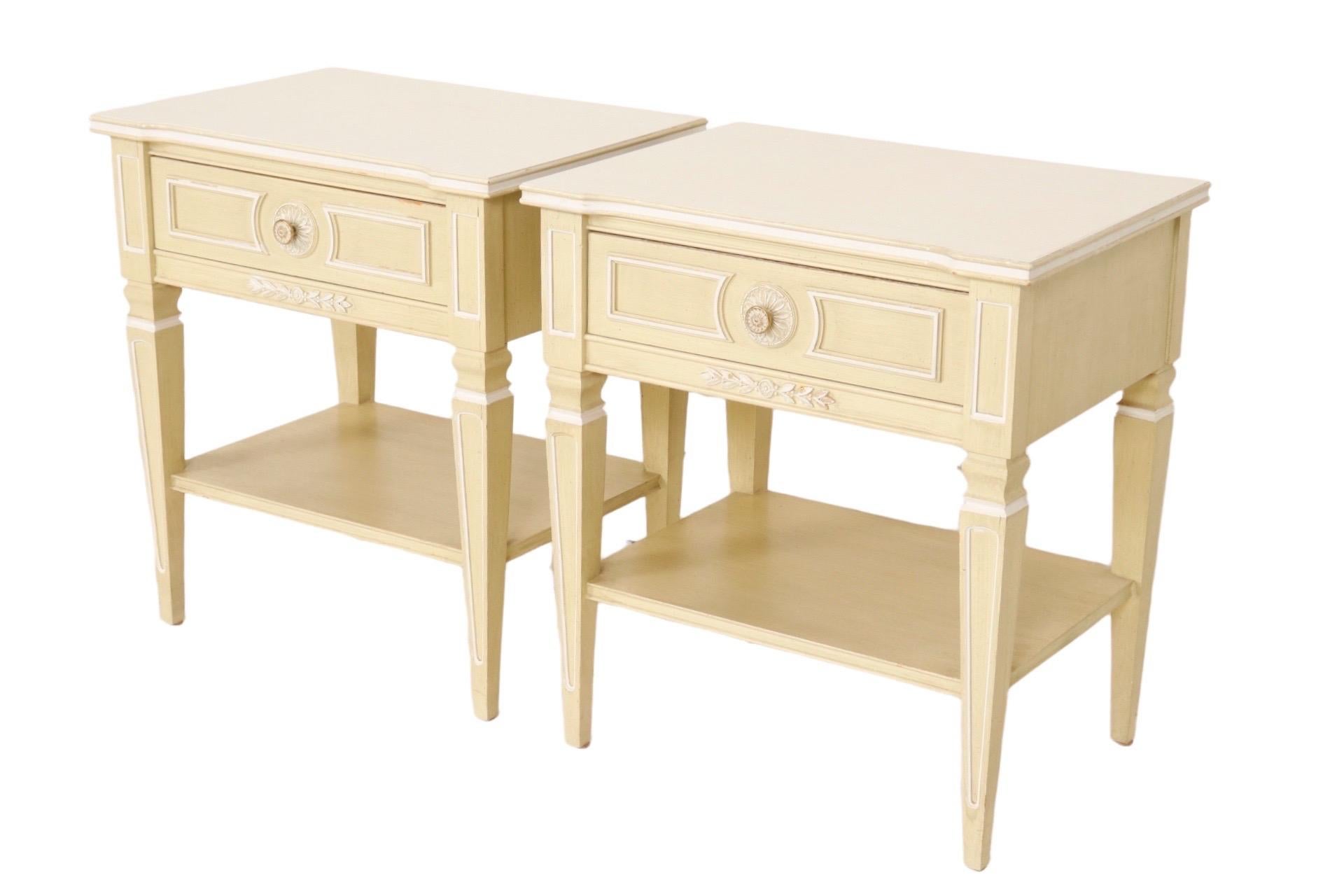 A Louis XVI style pair of side tables or nightstands made by Thomasville Furniture Industries of North Carolina. Each has a single drawer that opens with a flower pressed round metal handle. Drawer fronts are beaded to give the look of panels around