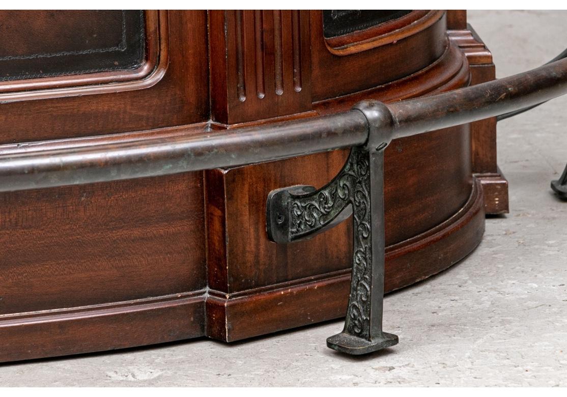 A very well made and interesting design with a black marble/ Fossil Stone Demi-lune top and figured panels on the front. The frieze set with fine verdigris cast brass African animal heads, the patinated metal foot rail with decorated legs. The back