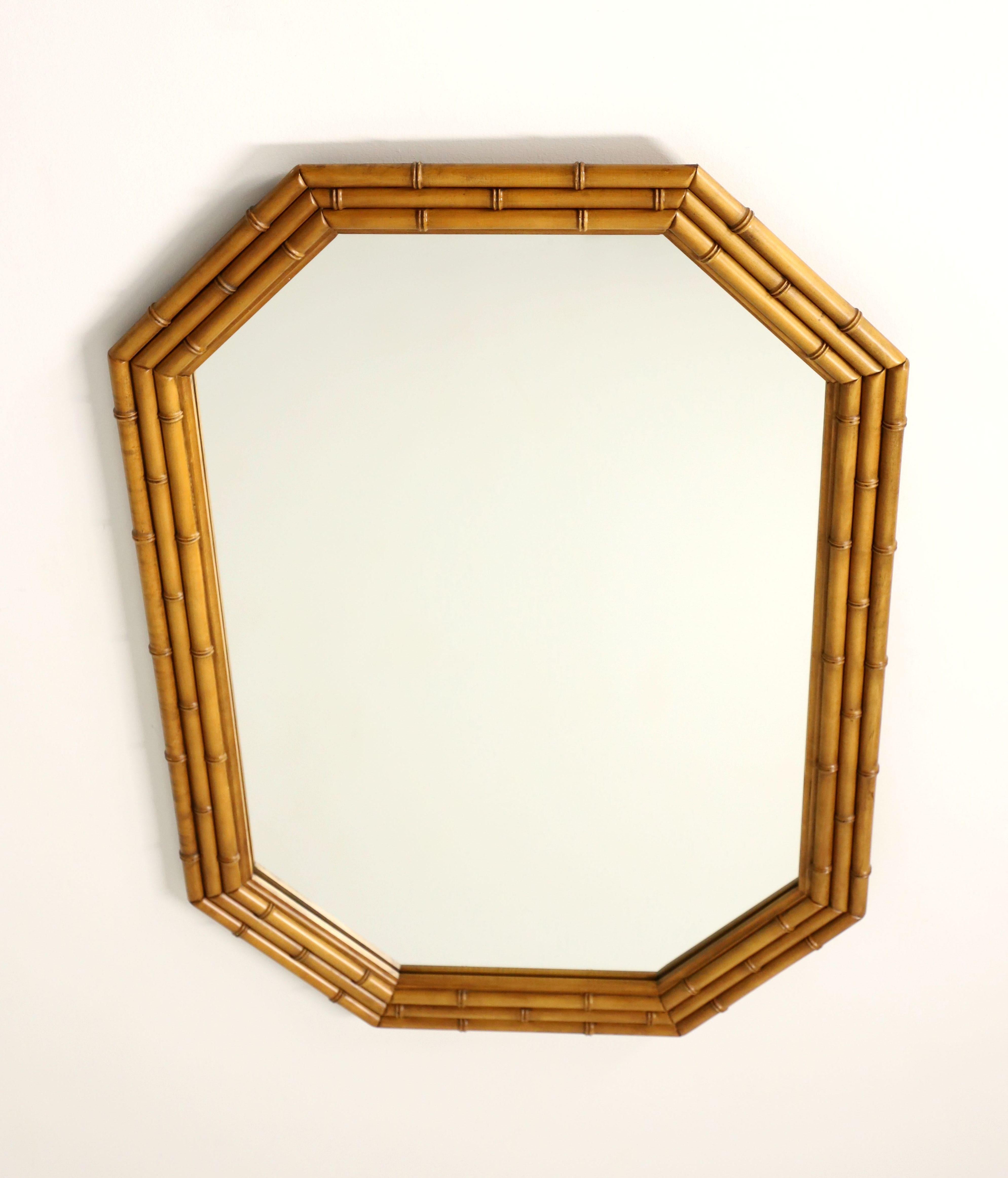 An Asian style wall mirror by Lenoir Mirror for Thomasville. Mirror glass in a light brown wood tone faux bamboo frame. Features an octagonal shape with faux bamboo detail to the frame. Made in Lenoir, North Carolina, USA, in the late 20th