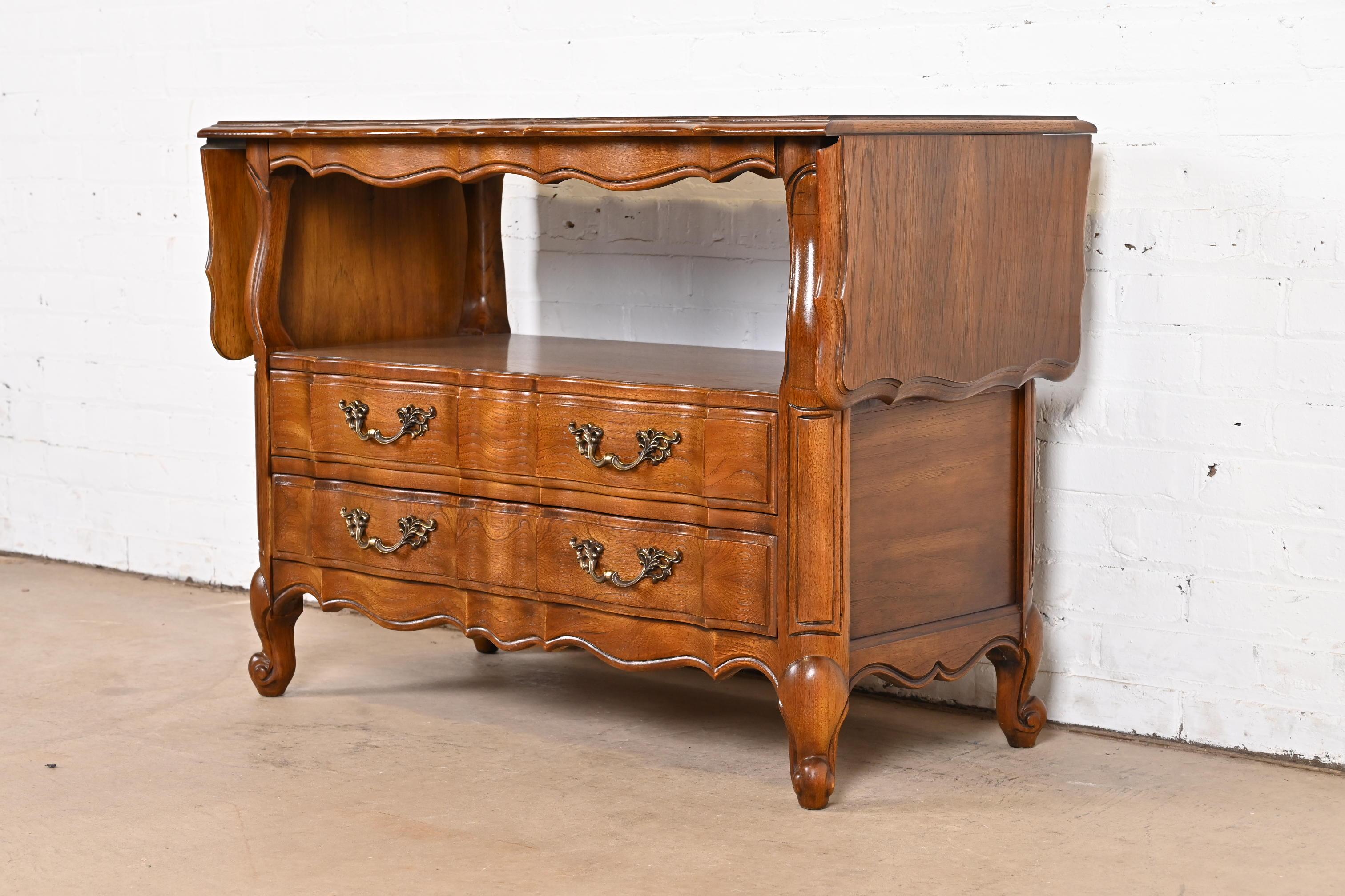 A beautiful French Provincial Louis XV style drop leaf buffet server or bar cabinet

By Thomasville

USA, Circa 1970s

Carved pecan wood, with original brass hardware.

Measures: 39