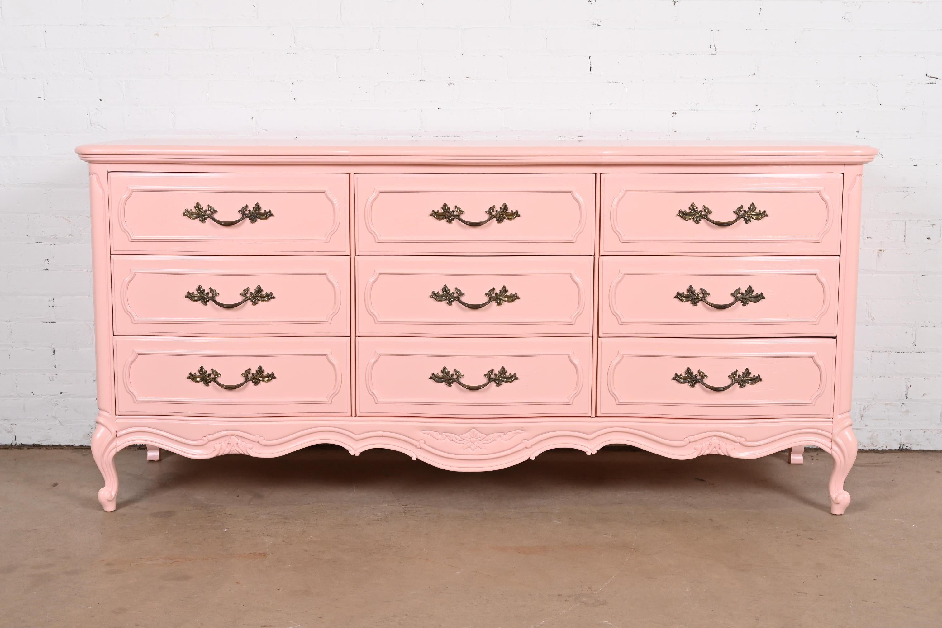 A gorgeous French Provincial Louis XV style nine-drawer triple dresser or credenza

By Thomasville

USA, Circa 1970s

Pink lacquered solid oak, with original brass hardware.

Measures: 68