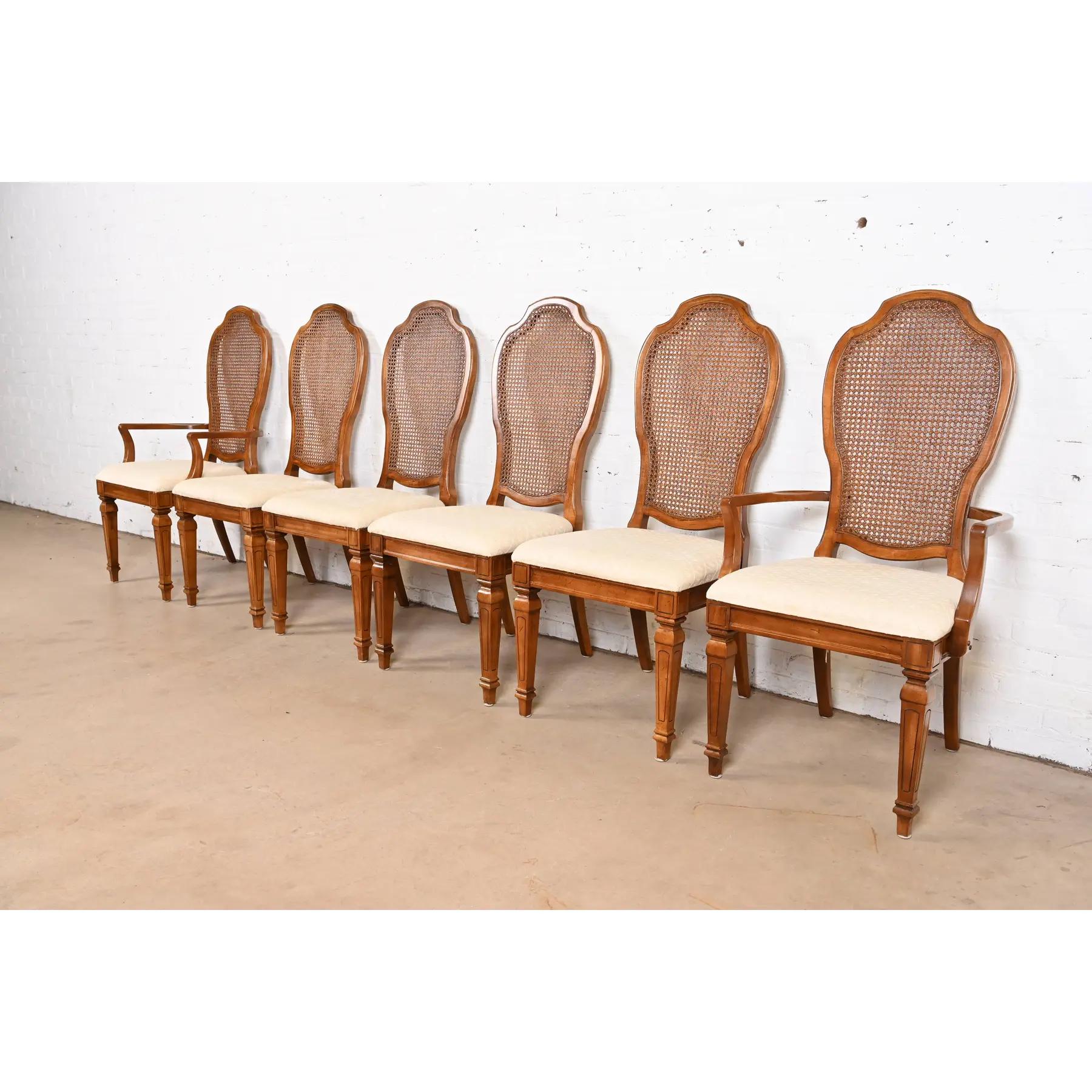 A gorgeous set of six French Regency Louis XVI style dining chairs

By Thomasville

USA, Circa 1960s

Sculpted cherry wood frames, with caned backs, and upholstered seats.

Measures:
Side Chairs: 19.5