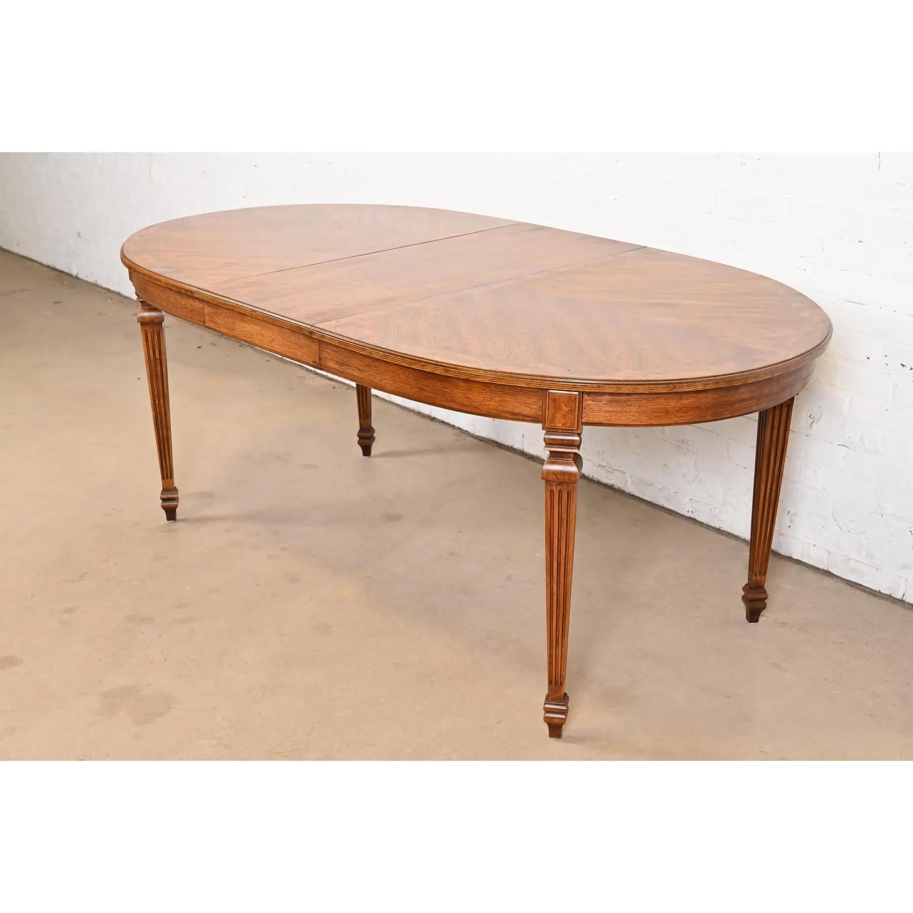 Magnifique table de salle à manger à rallonge de style Louis XVI de la Régence française

Par Thomasville

USA, Circa 1960

En noyer sculpté, avec un magnifique plateau en noyer assorti au livre et un bandeau en ronce de bois.

Dimensions : 58 