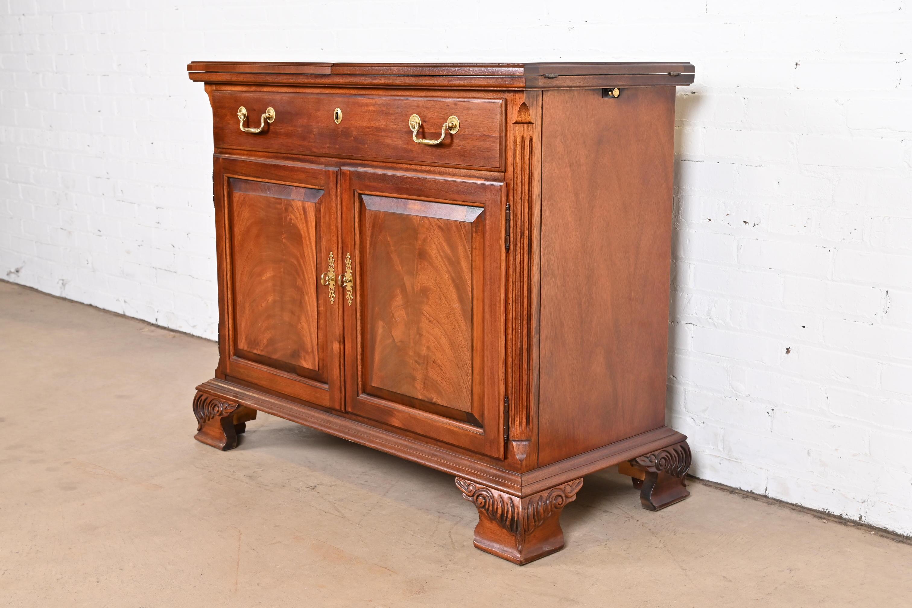 A beautiful Georgian or Chippendale style flip top buffet server or bar cabinet.

By Thomasville

USA, circa 1980s

Carved mahogany, with original brass hardware.

Measures: 40