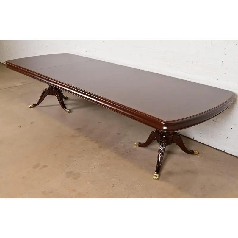 Exceptionnelle table de salle à manger à rallonge de style géorgien ou régence

Par Thomasville

USA, Circa 1980

Magnifique plateau en acajou flammé assorti aux livres, avec bandes de bois satiné, piédestaux en acajou massif sculpté et pieds en