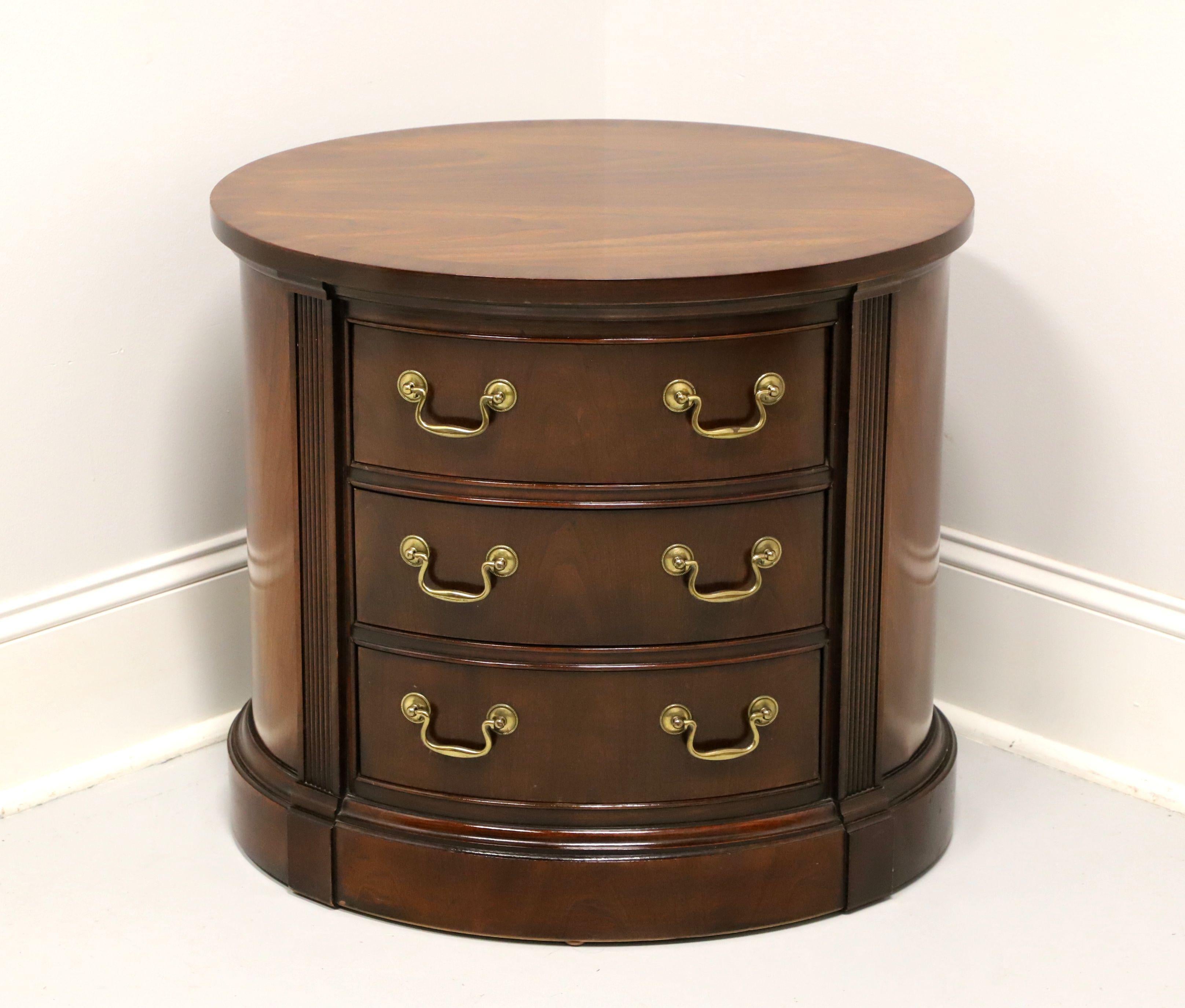 A Chippendale style oval shaped chairside chest by Thomasville. Mahogany with fluted column accents flanking drawers, brass hardware, fully finished back, and a solid base. Features three drawers of dovetail construction. Made in North Carolina,