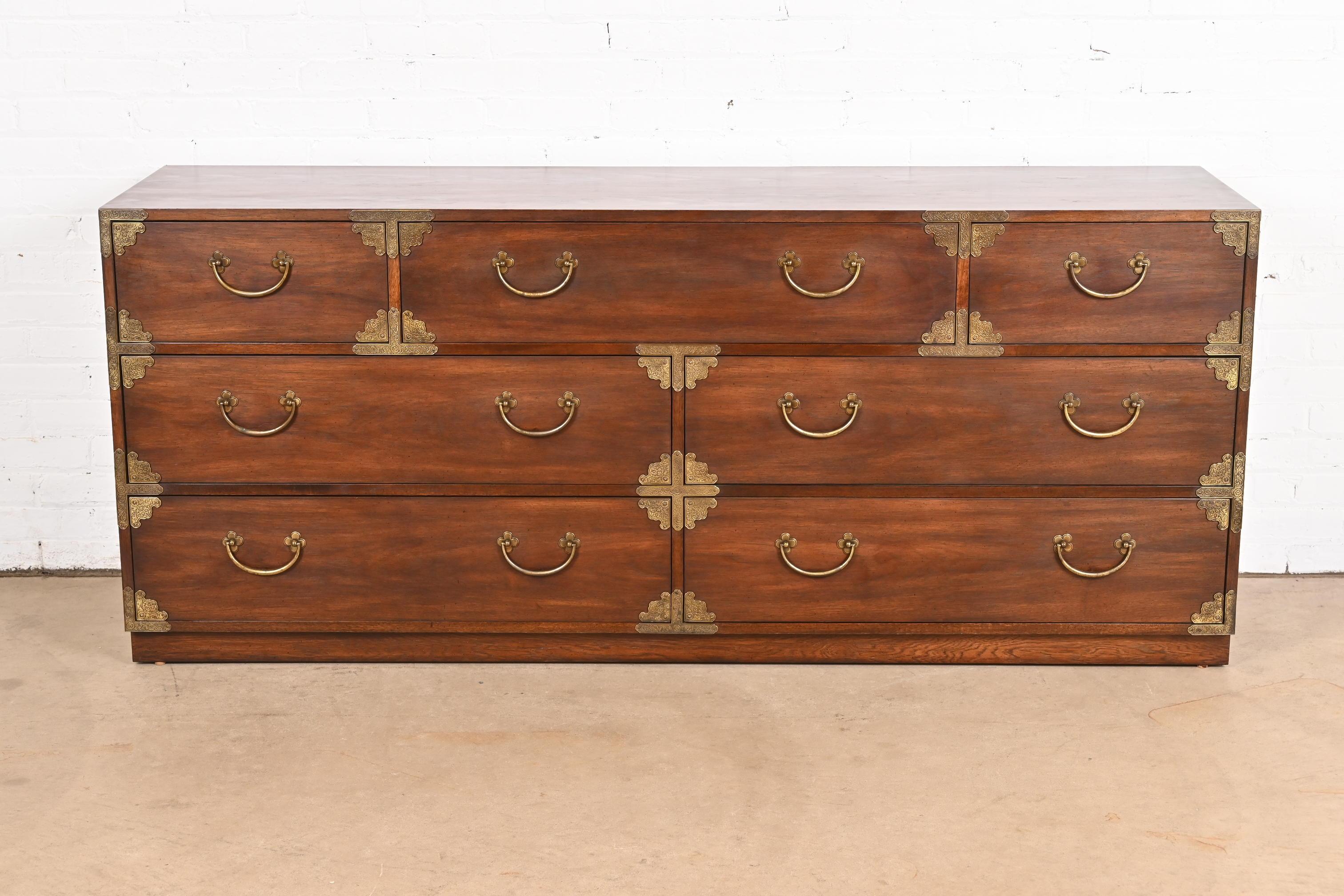 An exceptional mid-century modern Hollywood Regency Campaign style dresser or credenza

By Thomasville

USA, Circa 1970s

Gorgeous walnut, with original brass hardware and accents.

Measures: 72