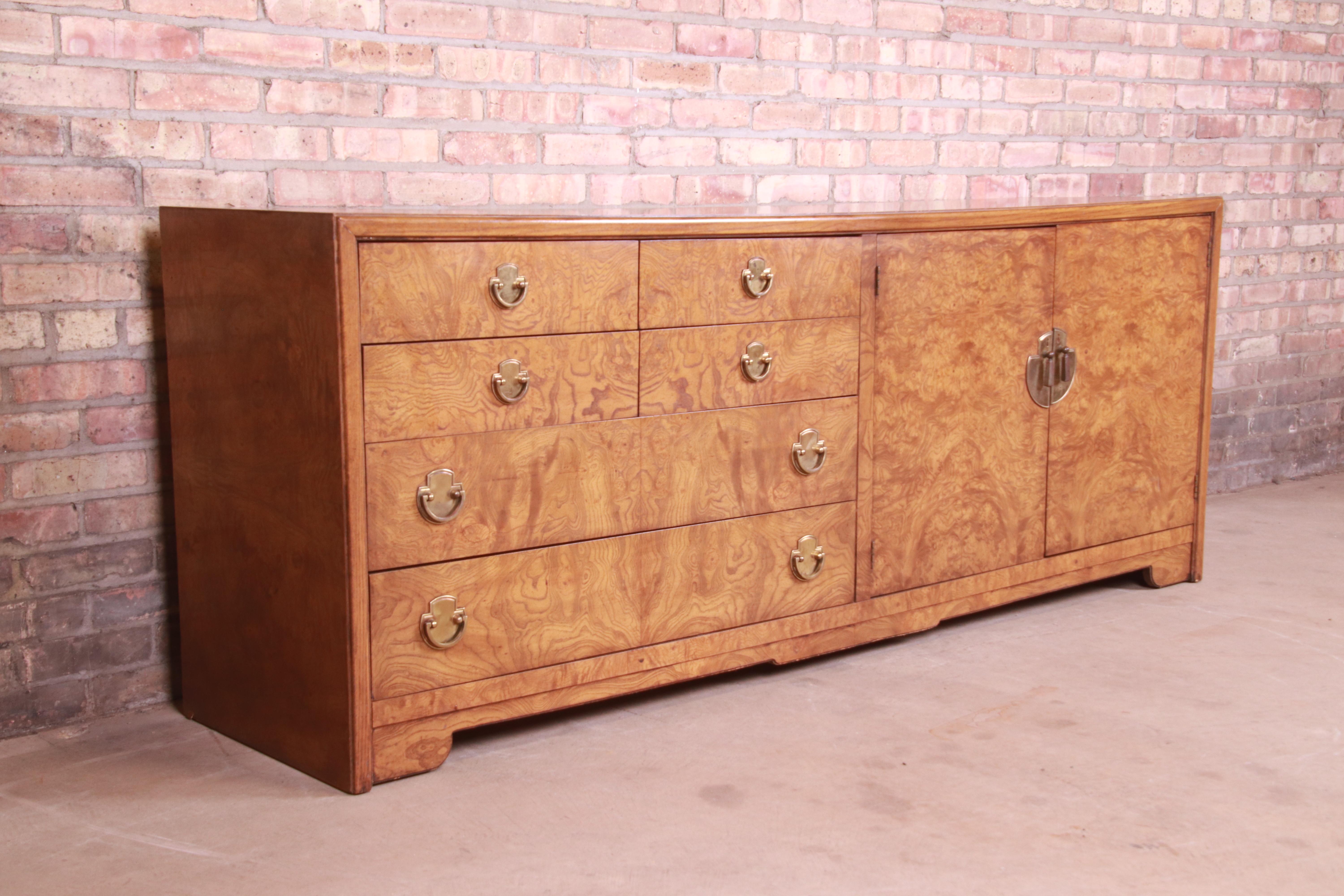 An exceptional Mid-Century Modern Hollywood Regency Chinoiserie dresser or credenza

By Thomasville

USA, 1970s

Burled olive wood, with original Asian-inspired brass hardware.

Measures: 78