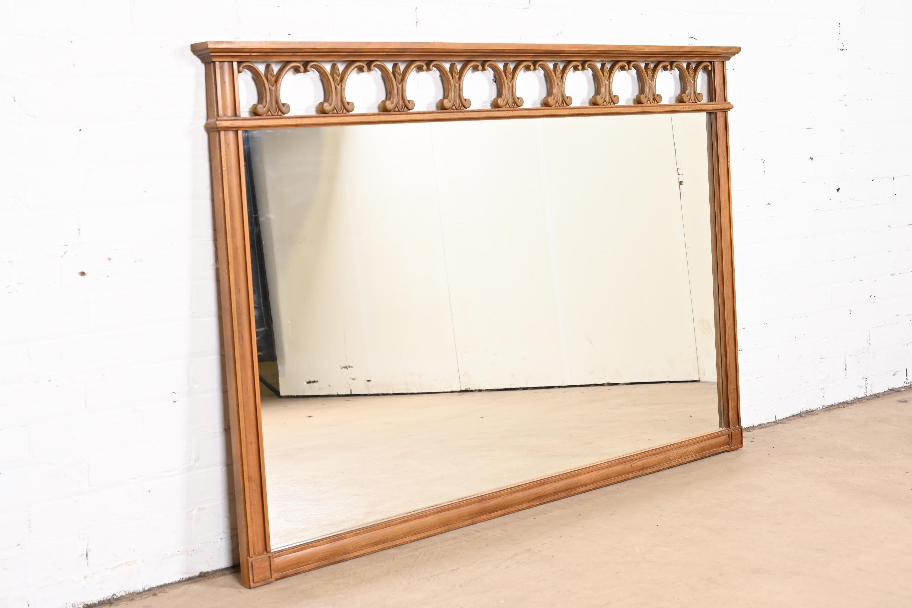 A stylish Mid-Century Modern Hollywood Regency sculpted walnut framed large wall mirror

By Thomasville

USA, circa 1960s

Measures: 59.5