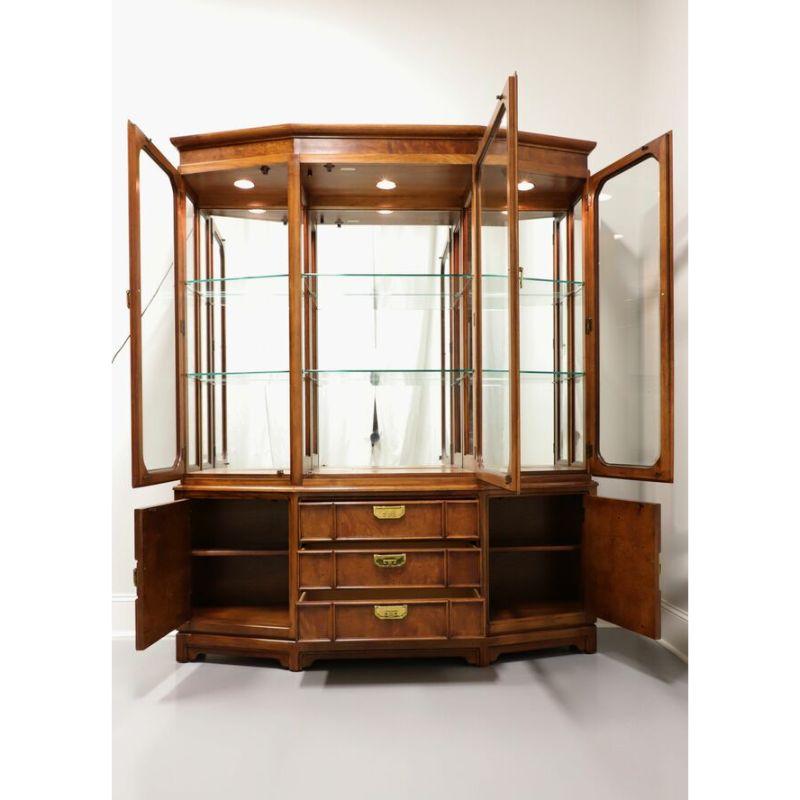 An Asian inspired china cabinet by Thomasville, from their Mystique Collection. Made circa 1990's in North Carolina, USA, of oak and burl oak with brass hardware. Upper lighted cabinet has glass side panels, a mirrored back and six adjustable